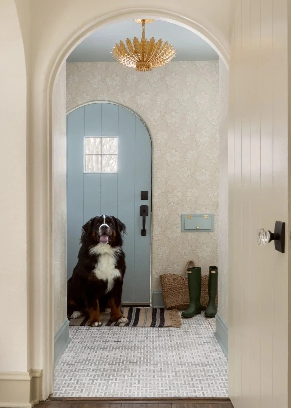 Whitefish Bay Tudor entryway with arched doorway and classic tile flooring. 