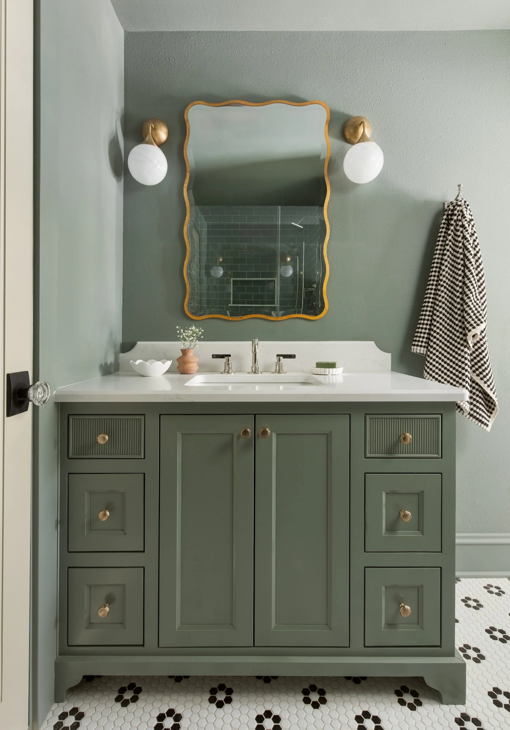 Whitefish Bay Tudor green color-drenched bathroom with green vanity and tiled floor