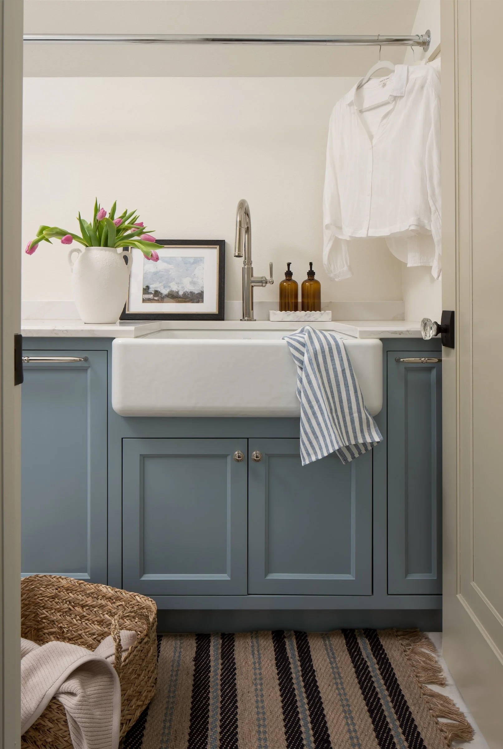 Whitefish Bay Tudor laundry room with blue cabinets and farmhouse sink