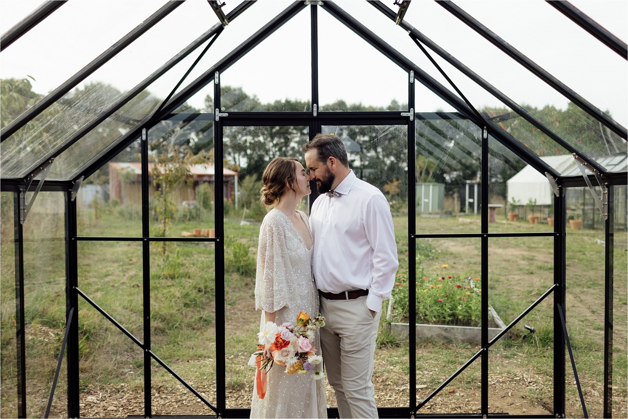  Bride and Groom standing together in a glasshouse  on their wedding day 
