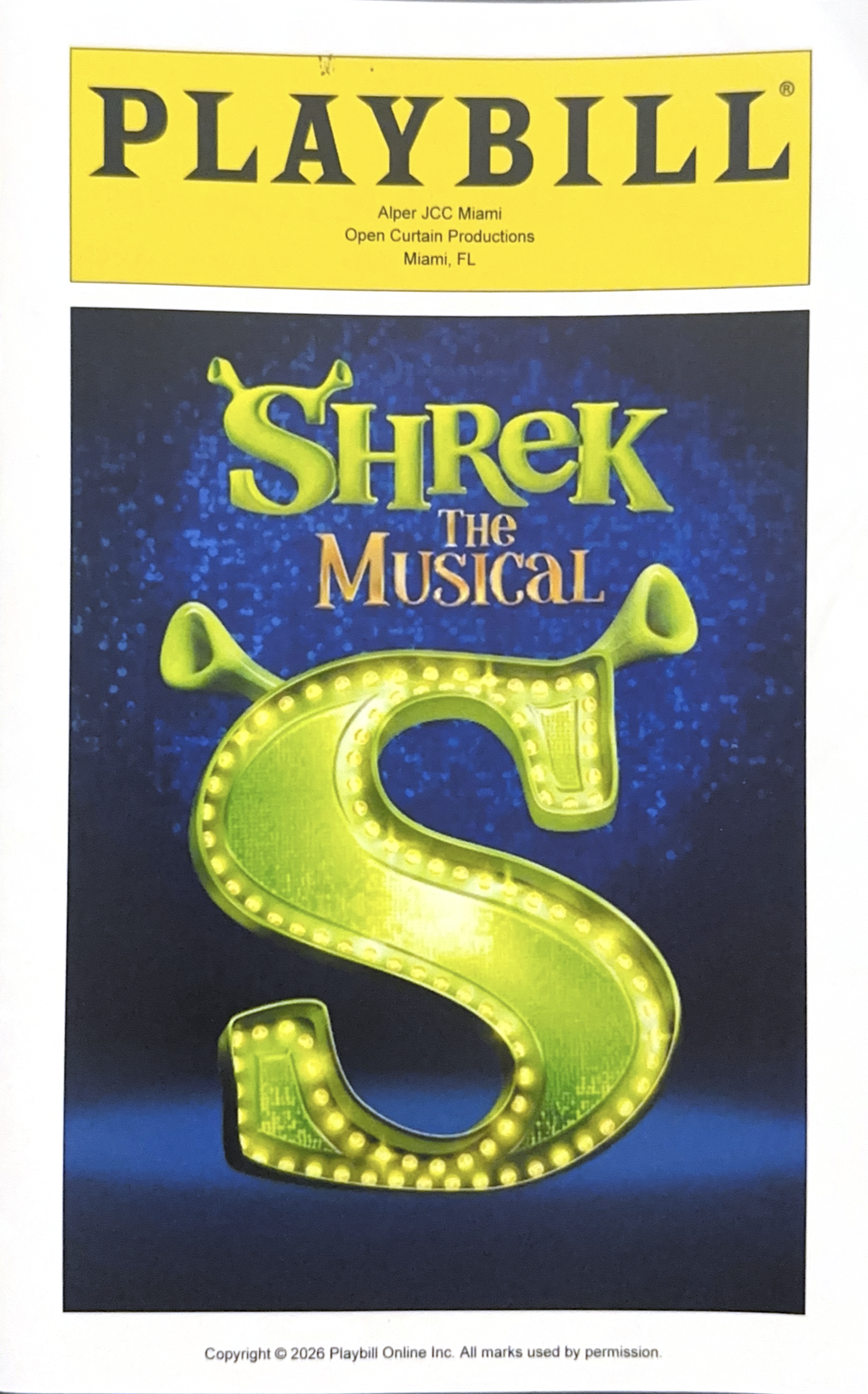 Playbill for Shrek The Musical, featuring a large illuminated yellow letter S with green ogre ears at the top, against a dark blue background, and a yellow Playbill banner at the top.