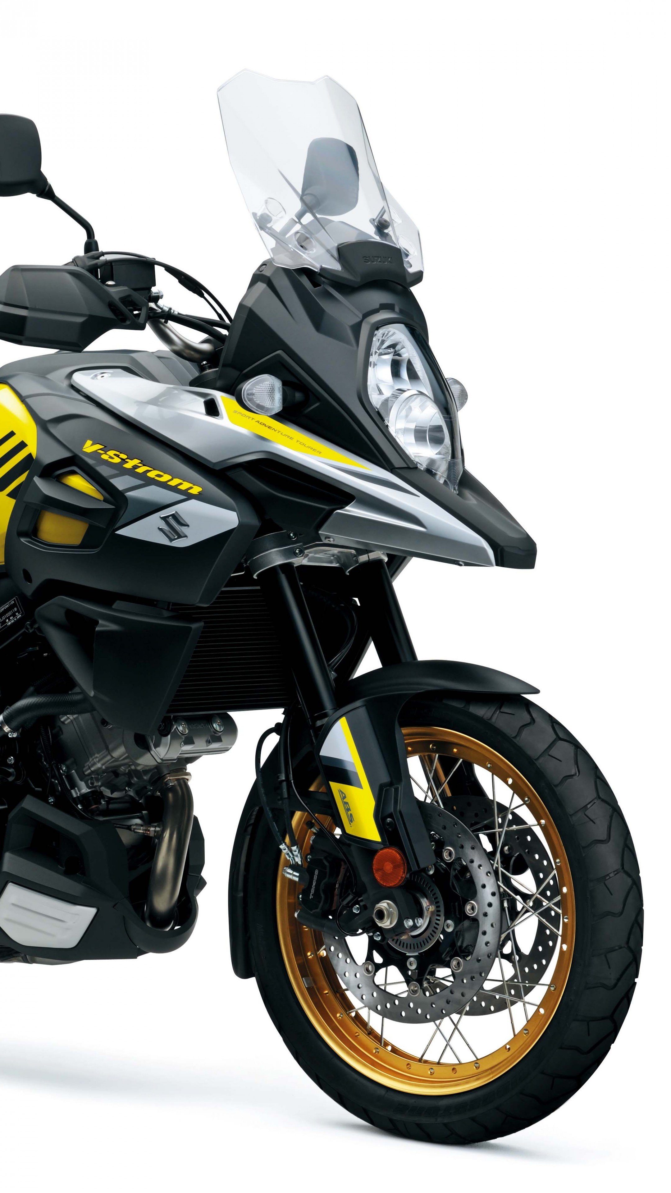 Close-up of a Suzuki V-Strom adventure motorcycle with black, gray, yellow accents, a clear windshield, gold rims, and front disc brake.