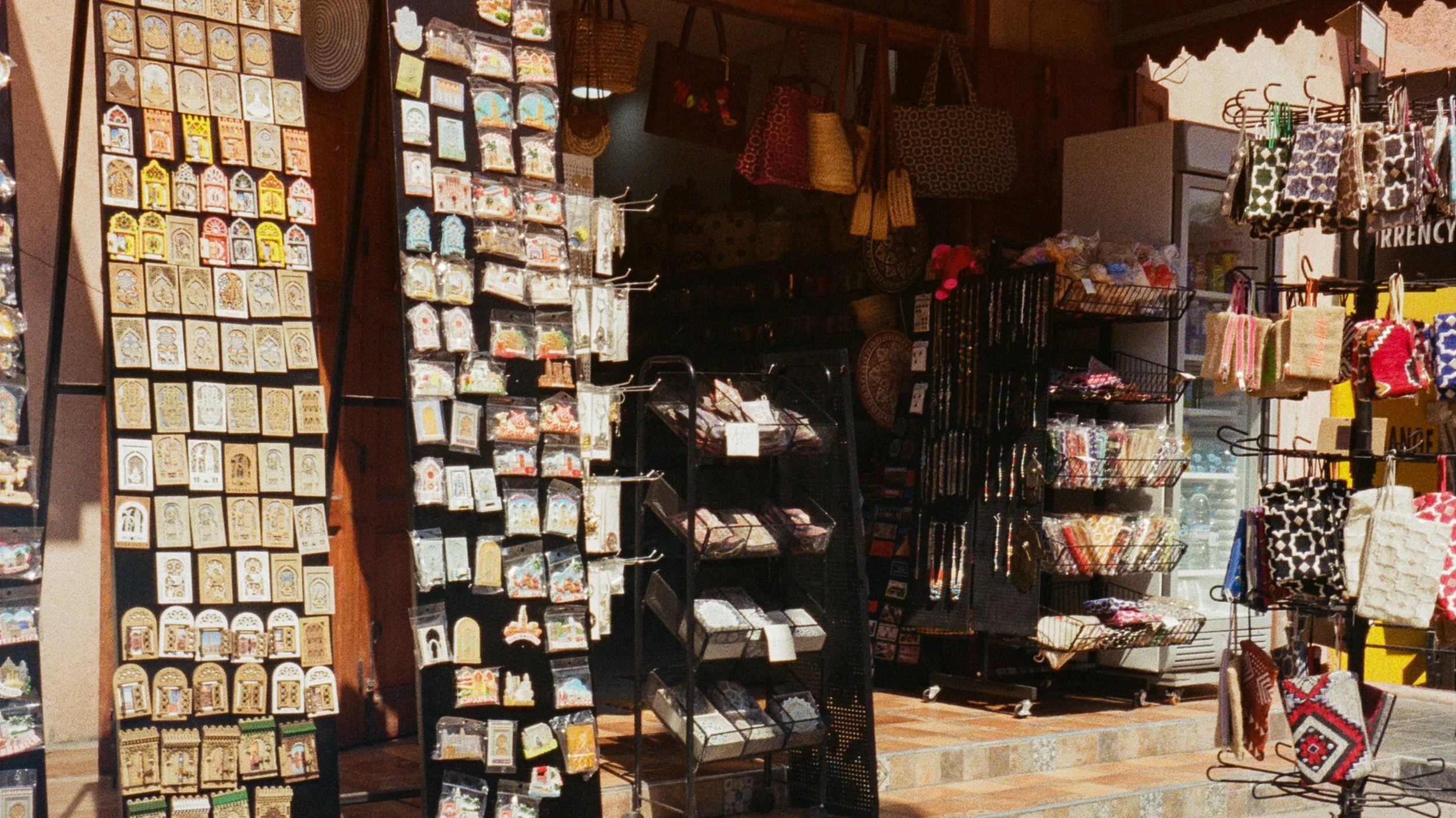 A display of various souvenirs including patches, bags, and decorative items in a store.