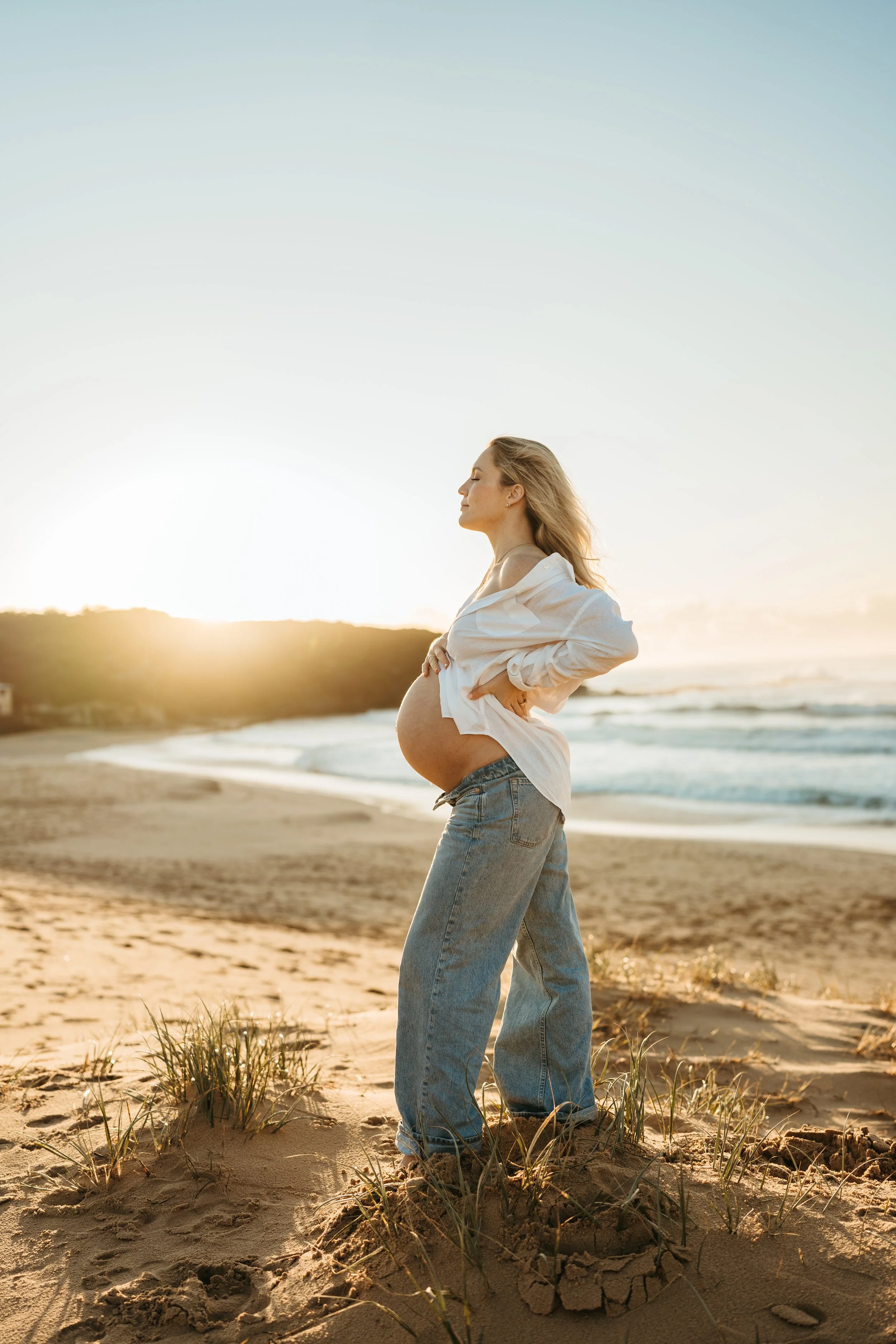 Pregnant woman at a relaxed maternity photography session on the beach at sunrise in Sydney
