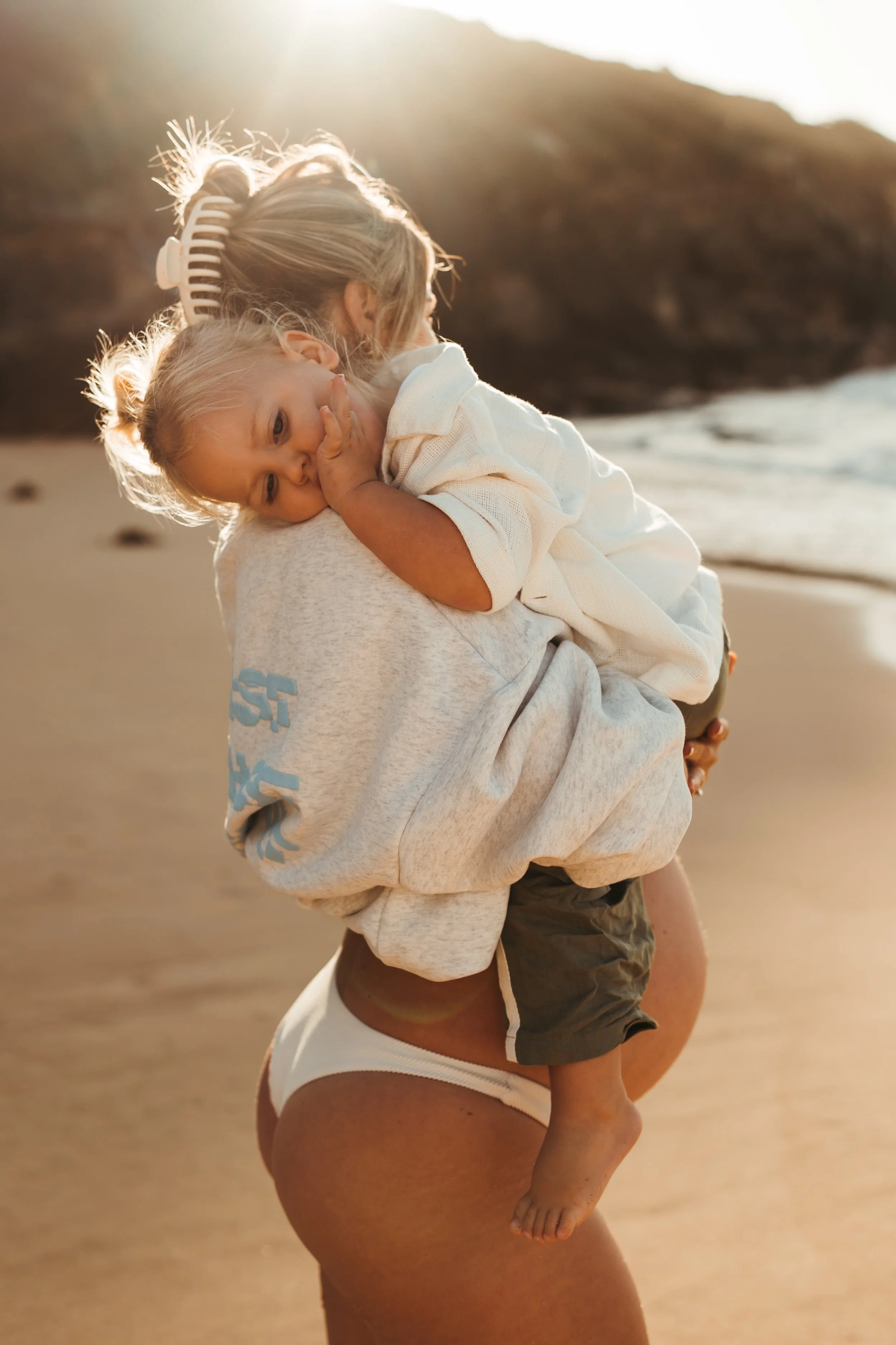 Pregnant woman cuddling toddler at a maternity photography session on Sydney's Northern Beaches