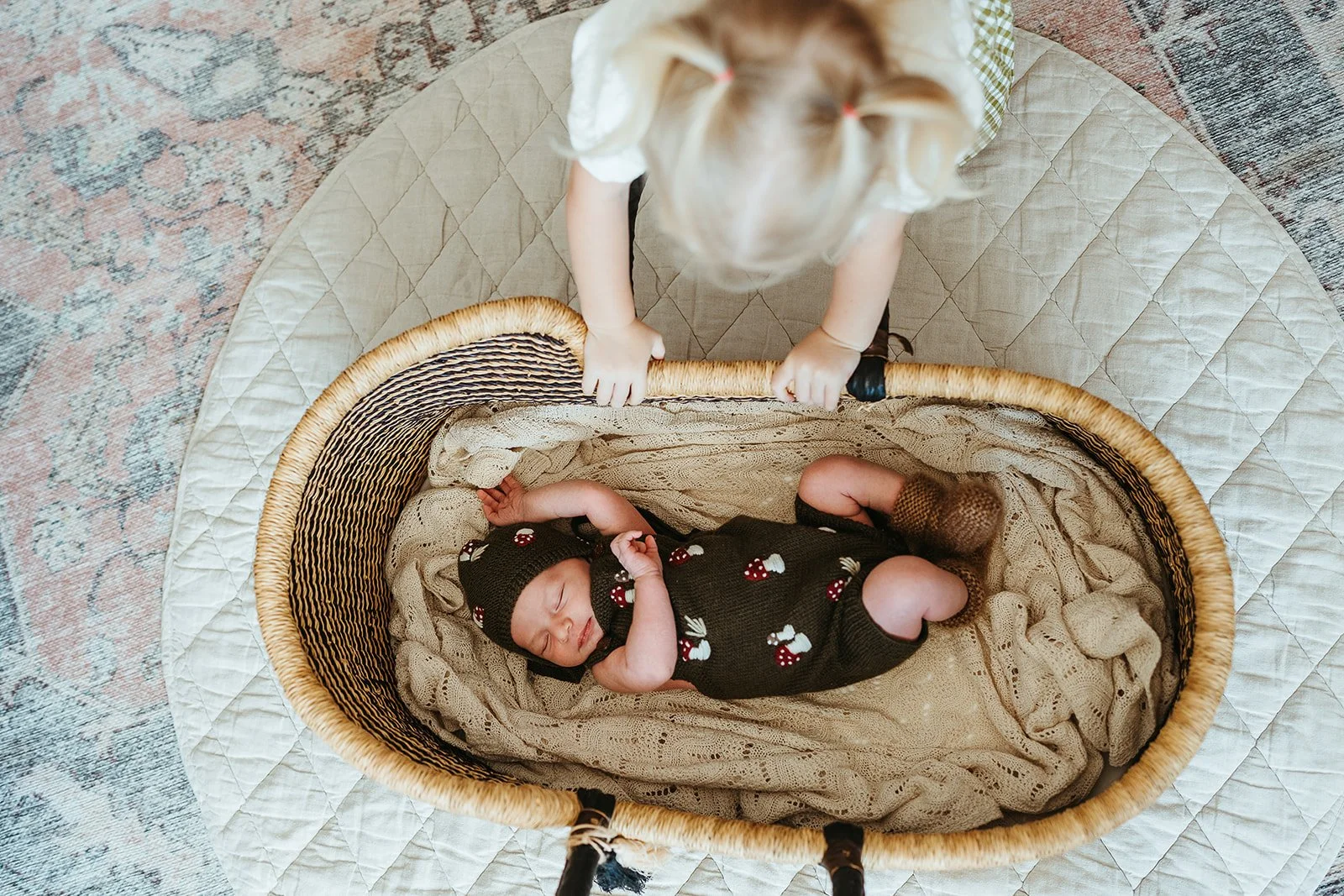 A toddler and newborn baby on a bed during an in-home family photography session with Sophie Smith Photography