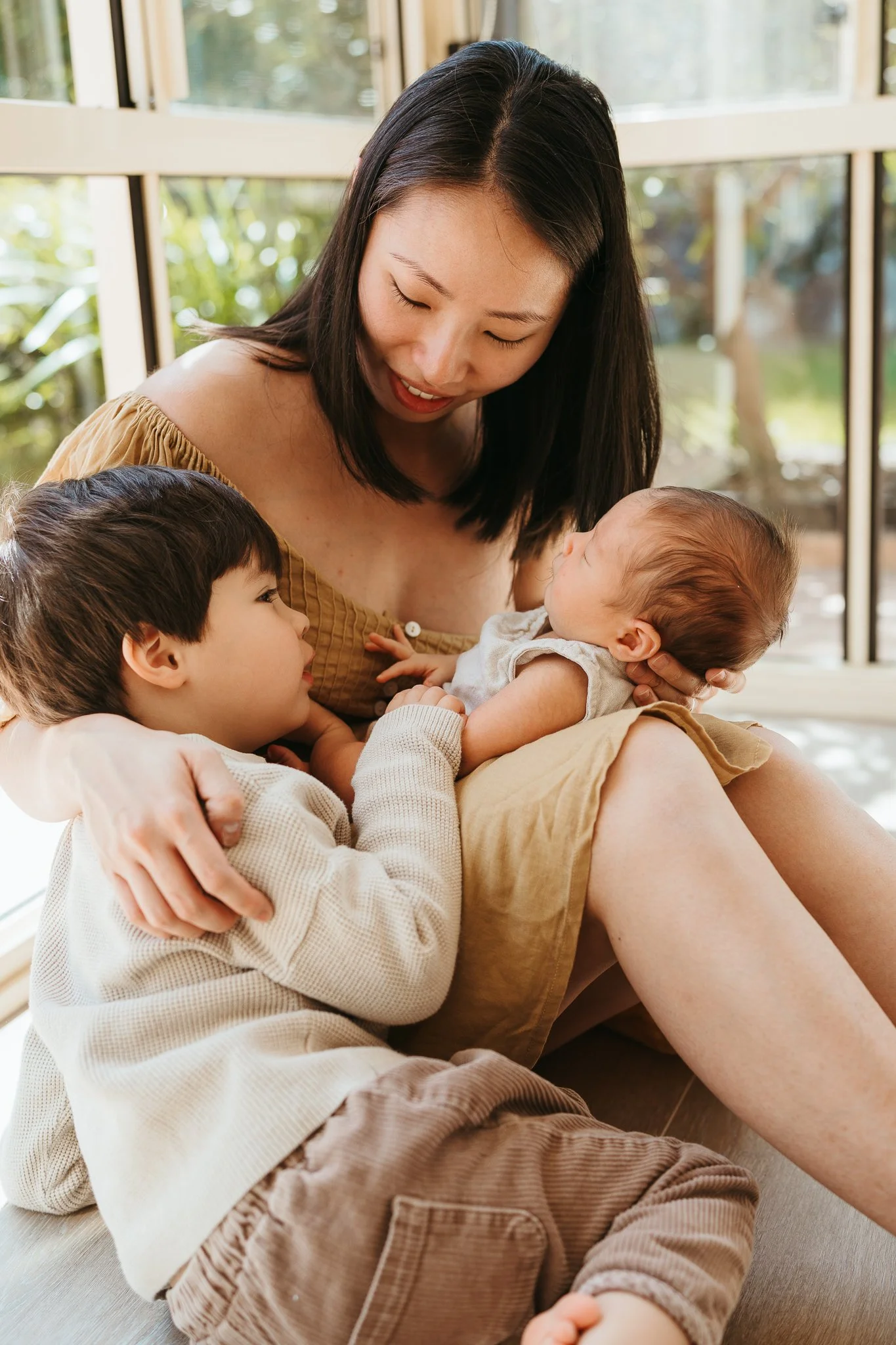 Mother with toddler and newborn baby at a relaxed, natural in-home photography session in Sydney