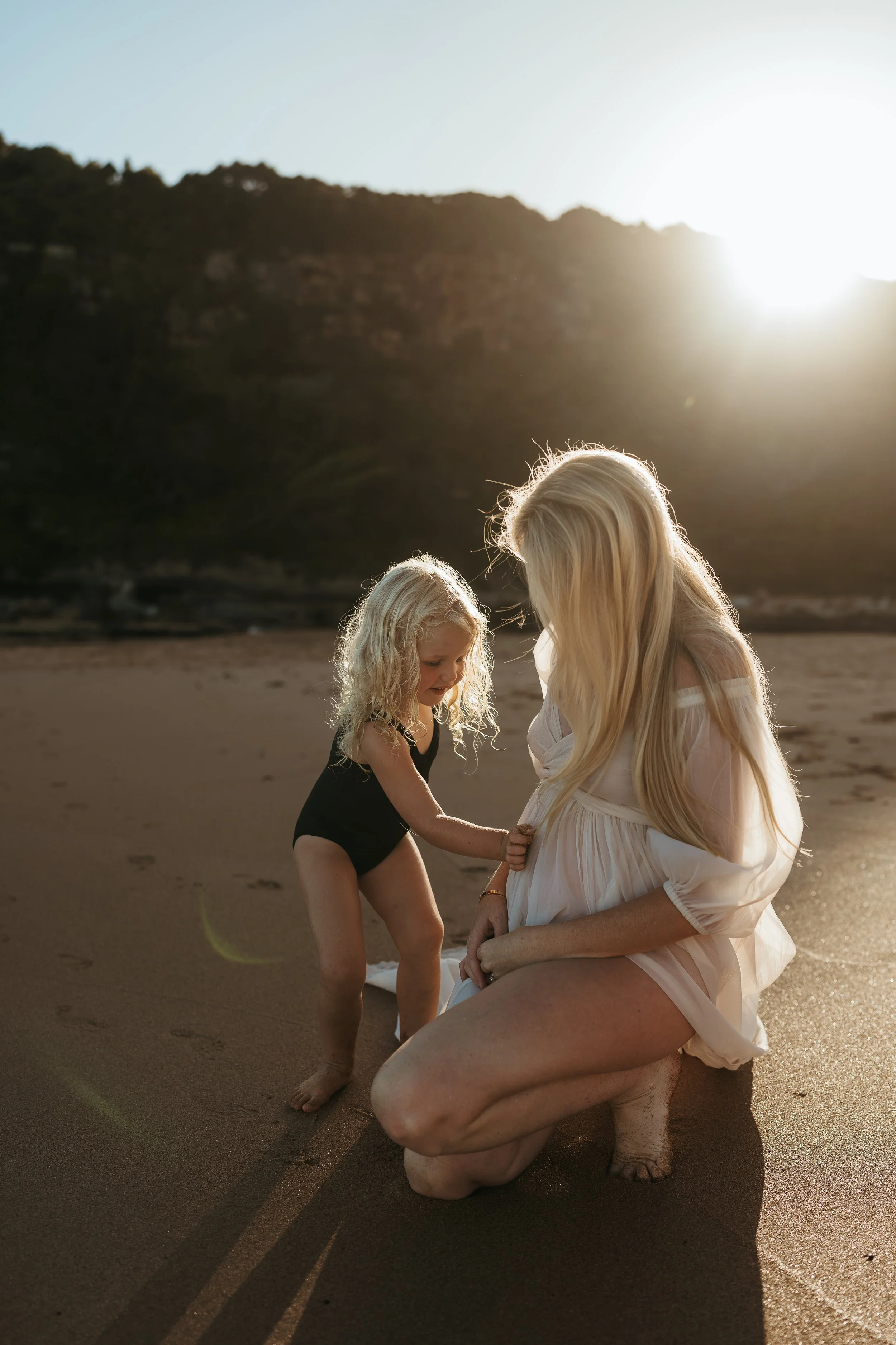 Pregnant woman and her toddler daughter at a relaxed maternity photography session on the beach in Sydney