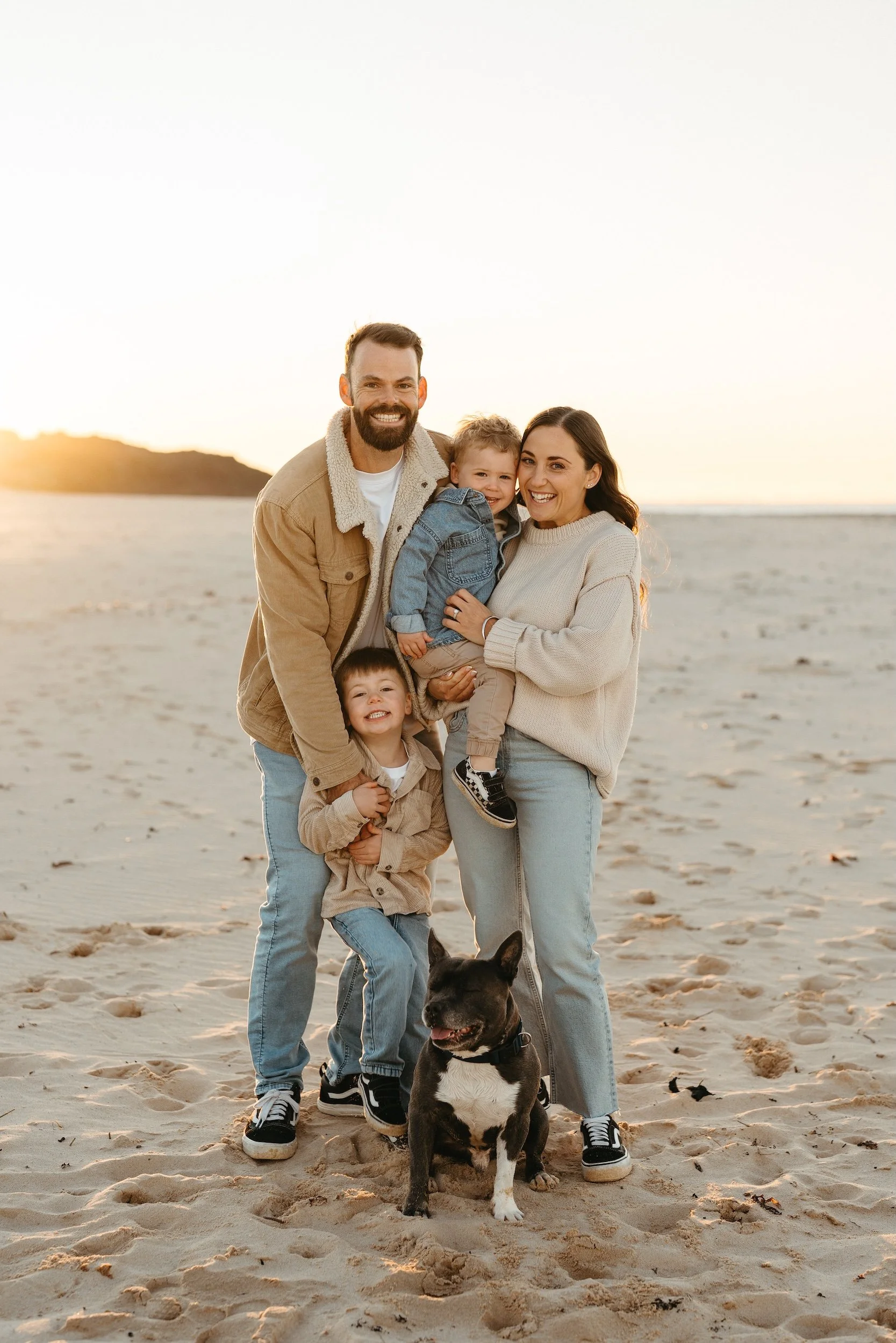 Photo of a family with two kids and their dog at at the beach during a family photography session on Sydney's Northern Beaches with Sophie Smith