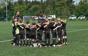 Soccer team huddled together on a field during practice or game