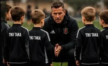 A coach speaking to young soccer players in black uniforms during practice or a game