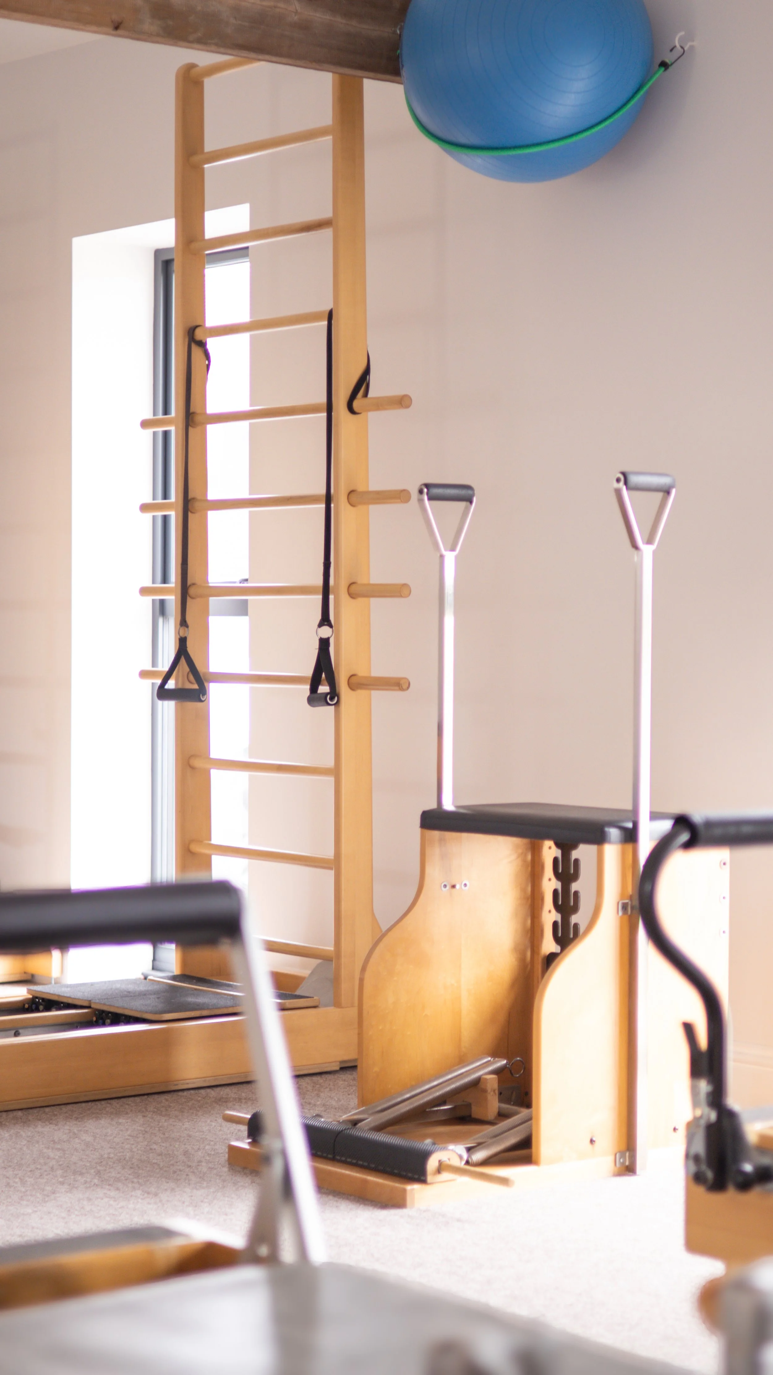 A photo of Pilates equipment including the split pedal chair, reformer and core align. Located at Tring Pilates Studio