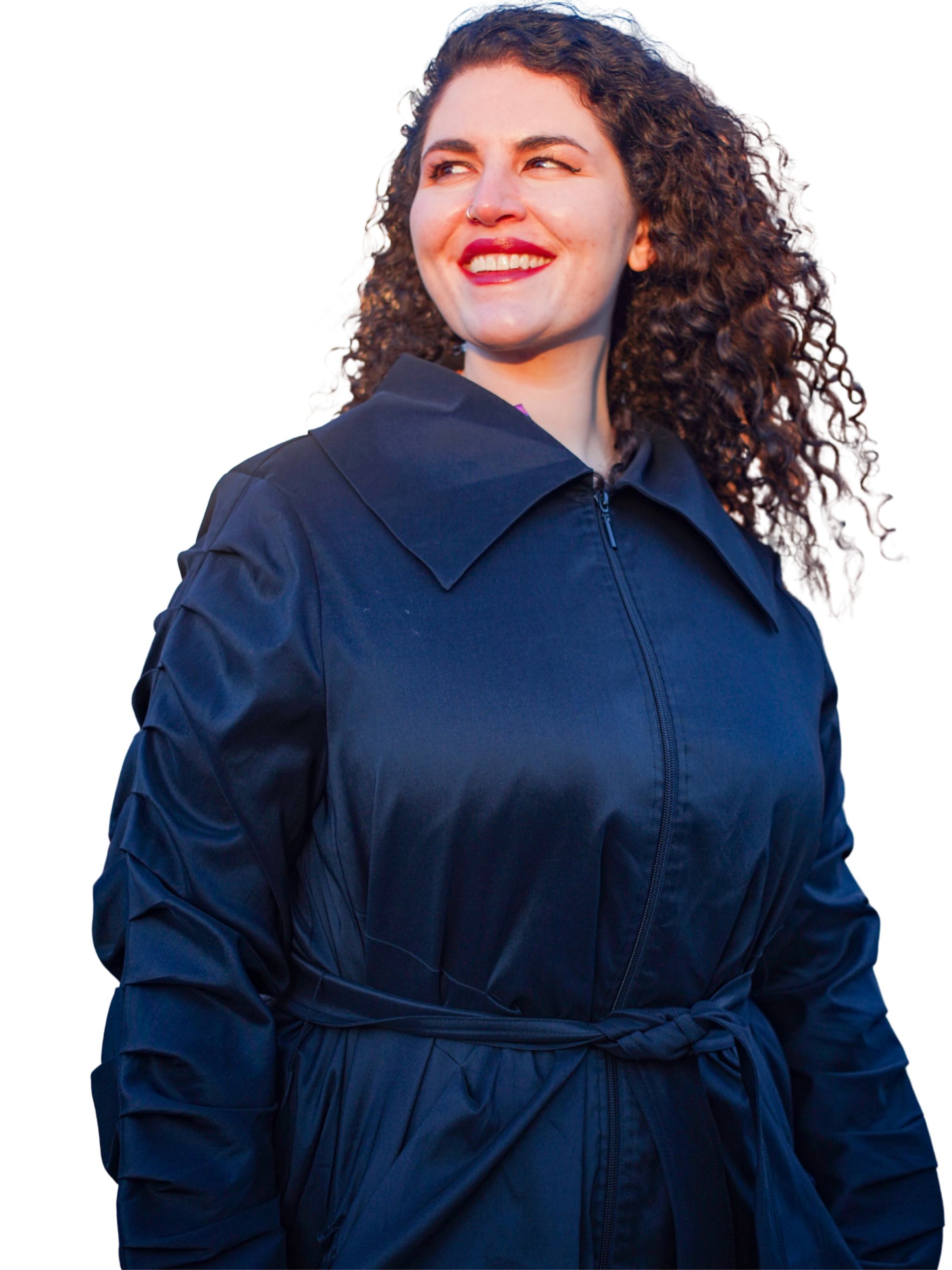 Meryl, somatic sex and intimacy coach, smiling and looking up to the left, wearing a black coat