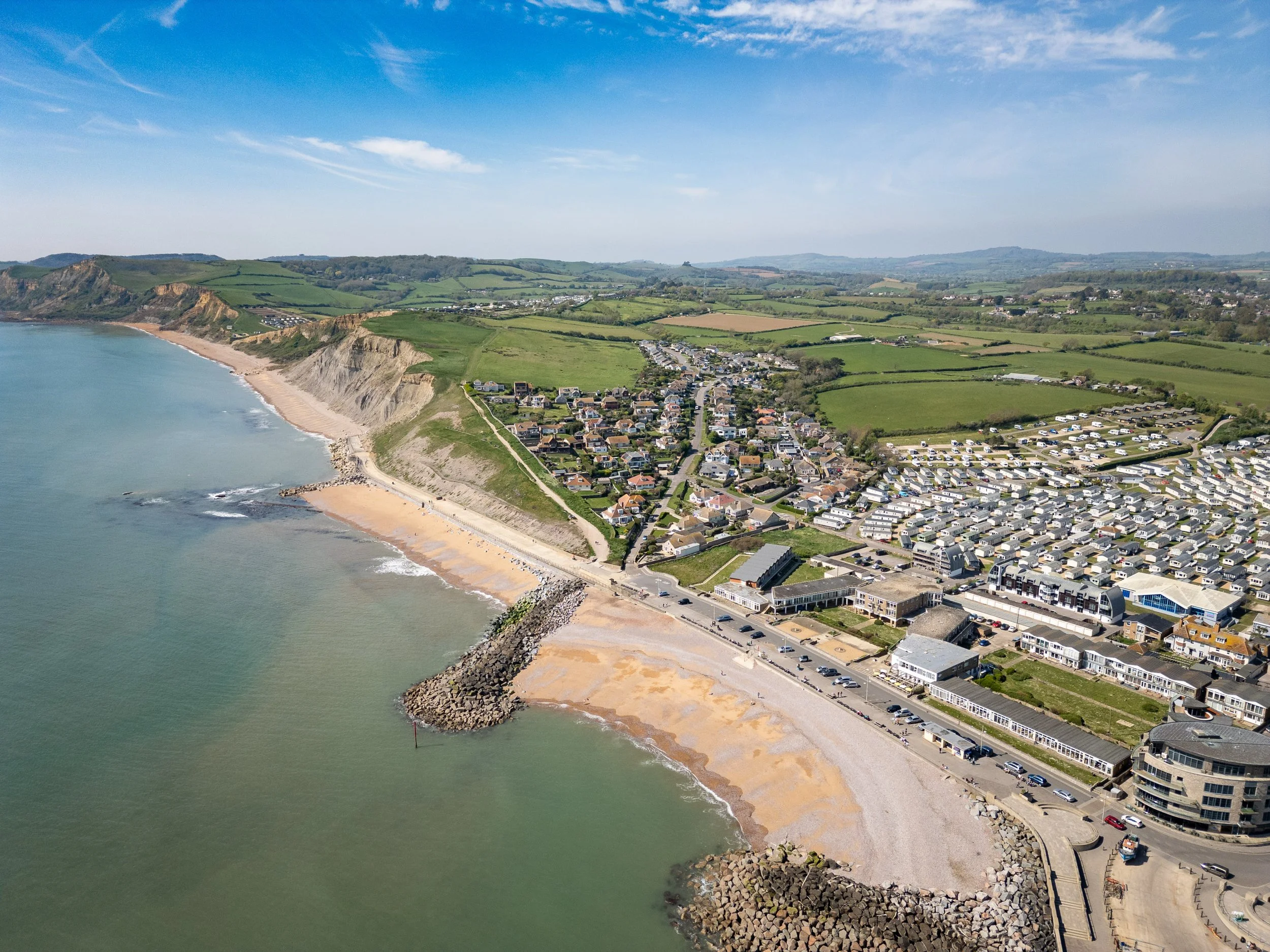 Drone photography of West Bay Dorset coastline with cliffs, beach, and holiday homes