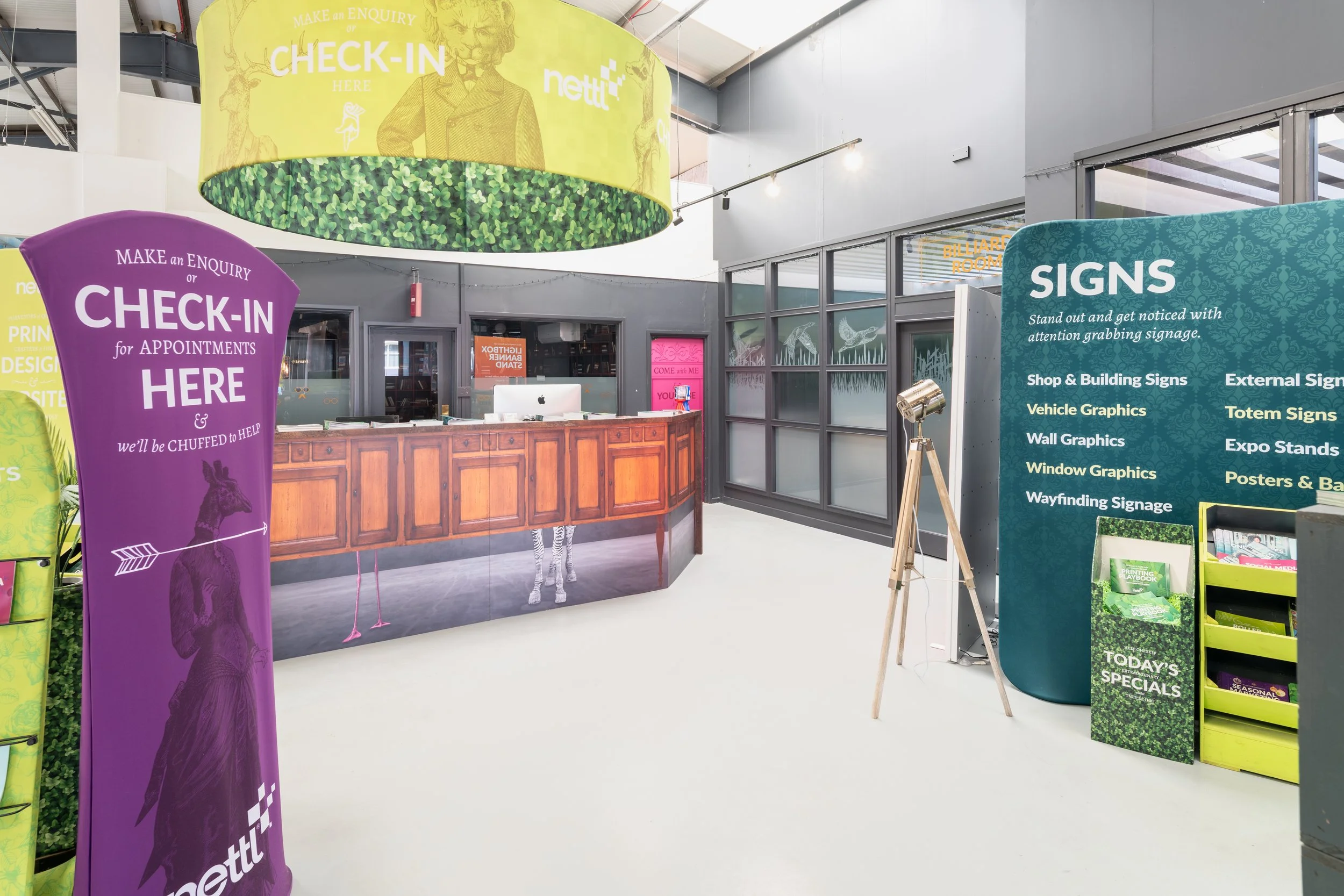Modern signage company reception area with branded check-in displays and commercial interior photography.