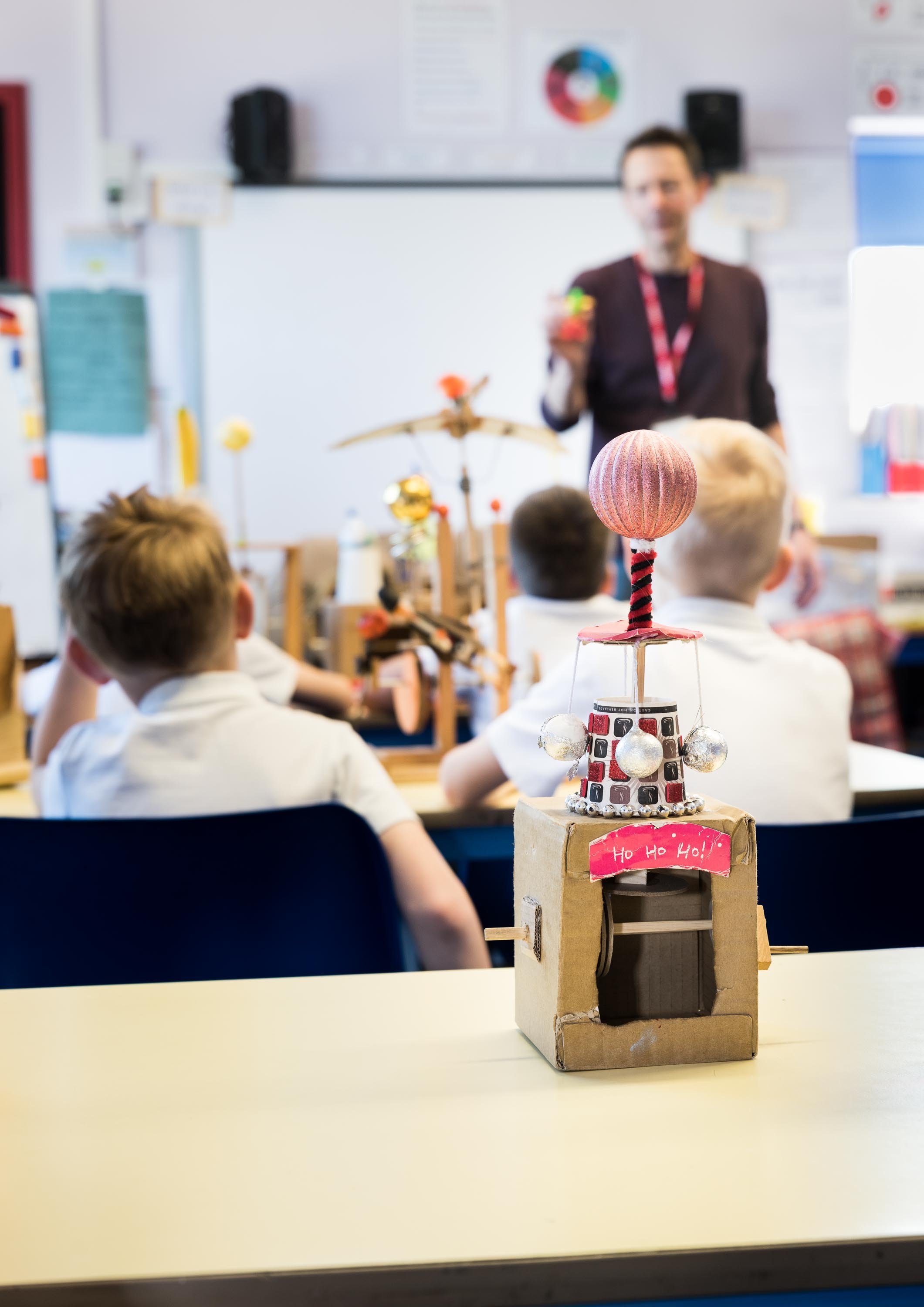 Simon Tutty expertly photographs a teacher discussing a subject with his students.