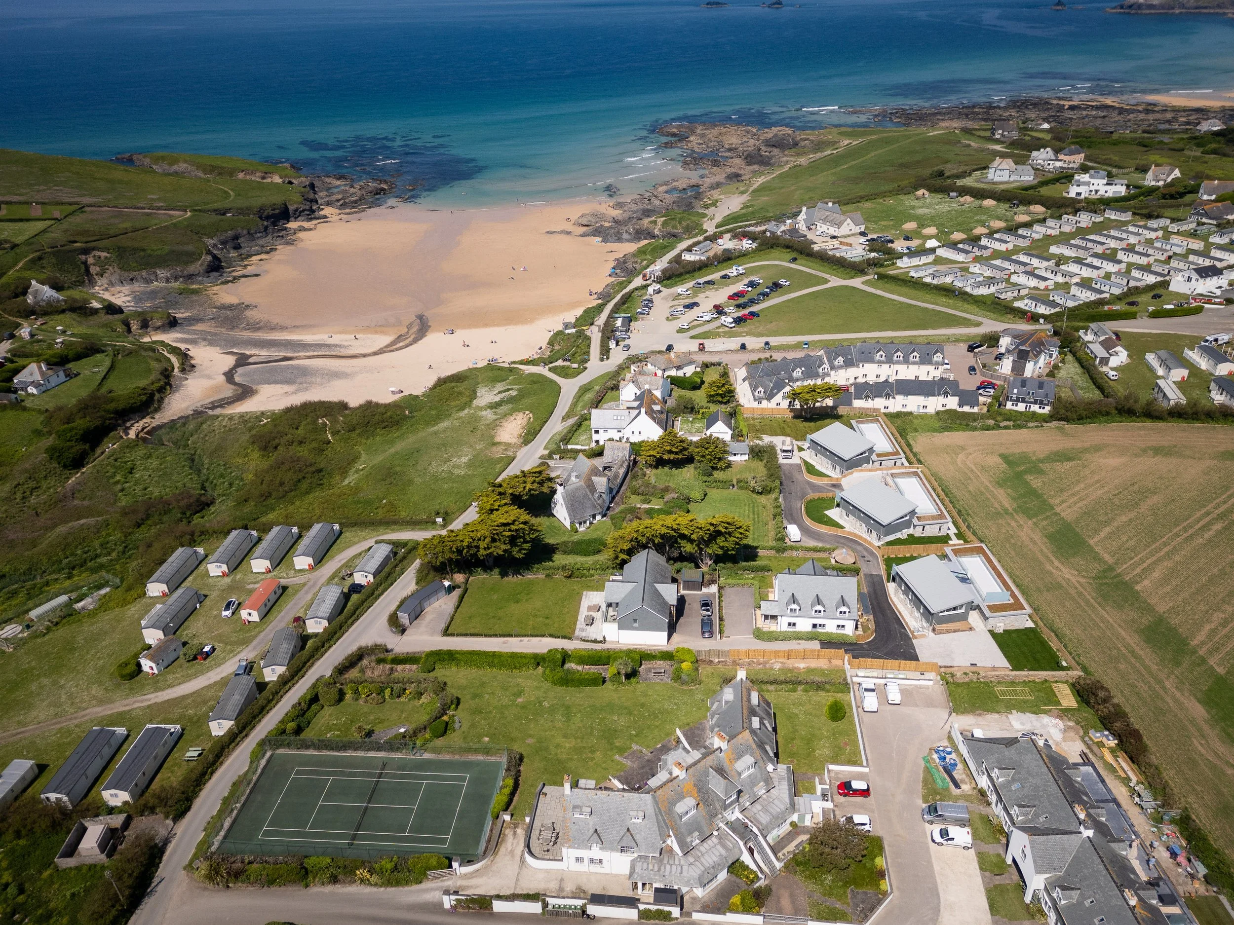 Drone photography of Treyarnon Bay in Cornwall with sandy beach, holiday homes, and coastline