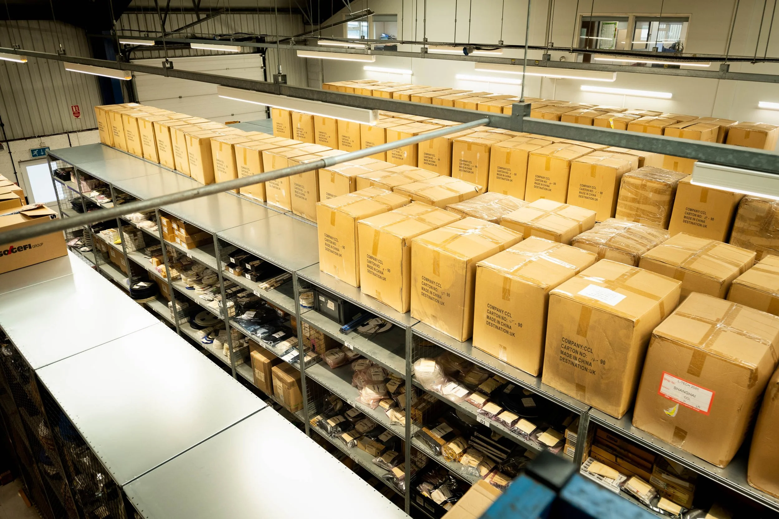 High view of warehouse shelving stacked with pallets and cartons for commercial storage and distribution.