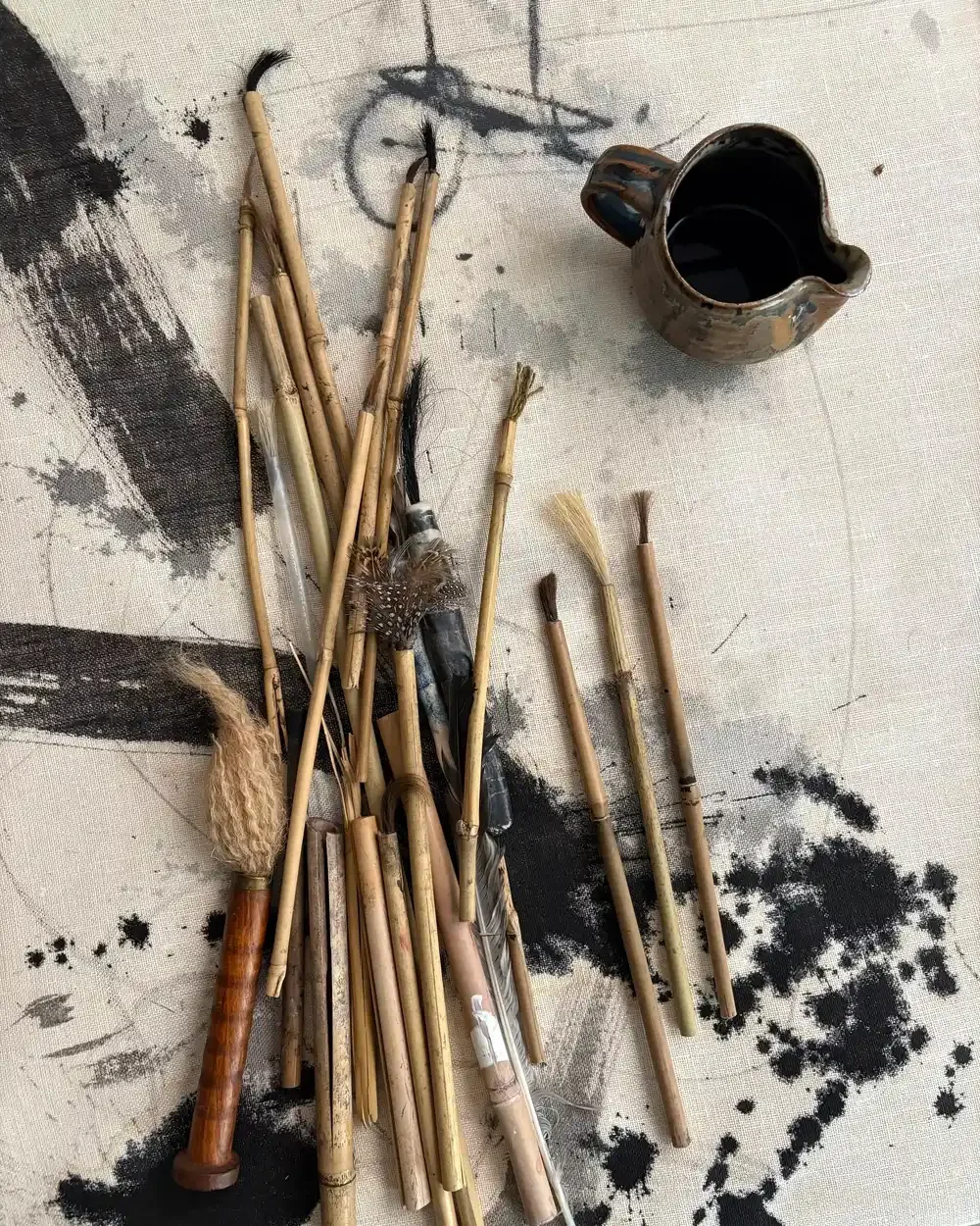 Paint brushes spread out on a messy canvas
