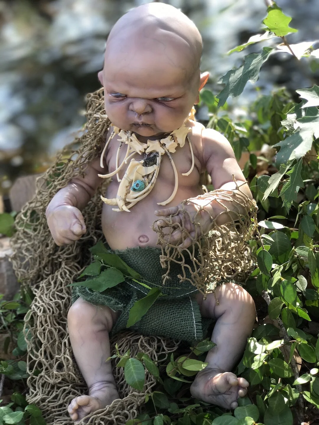 This grumpy little swamp baby was created by Kirsten Bjøre using the Maggie sculpt by Cindy Musgrove. Kirsten also made his bone necklace and costume.