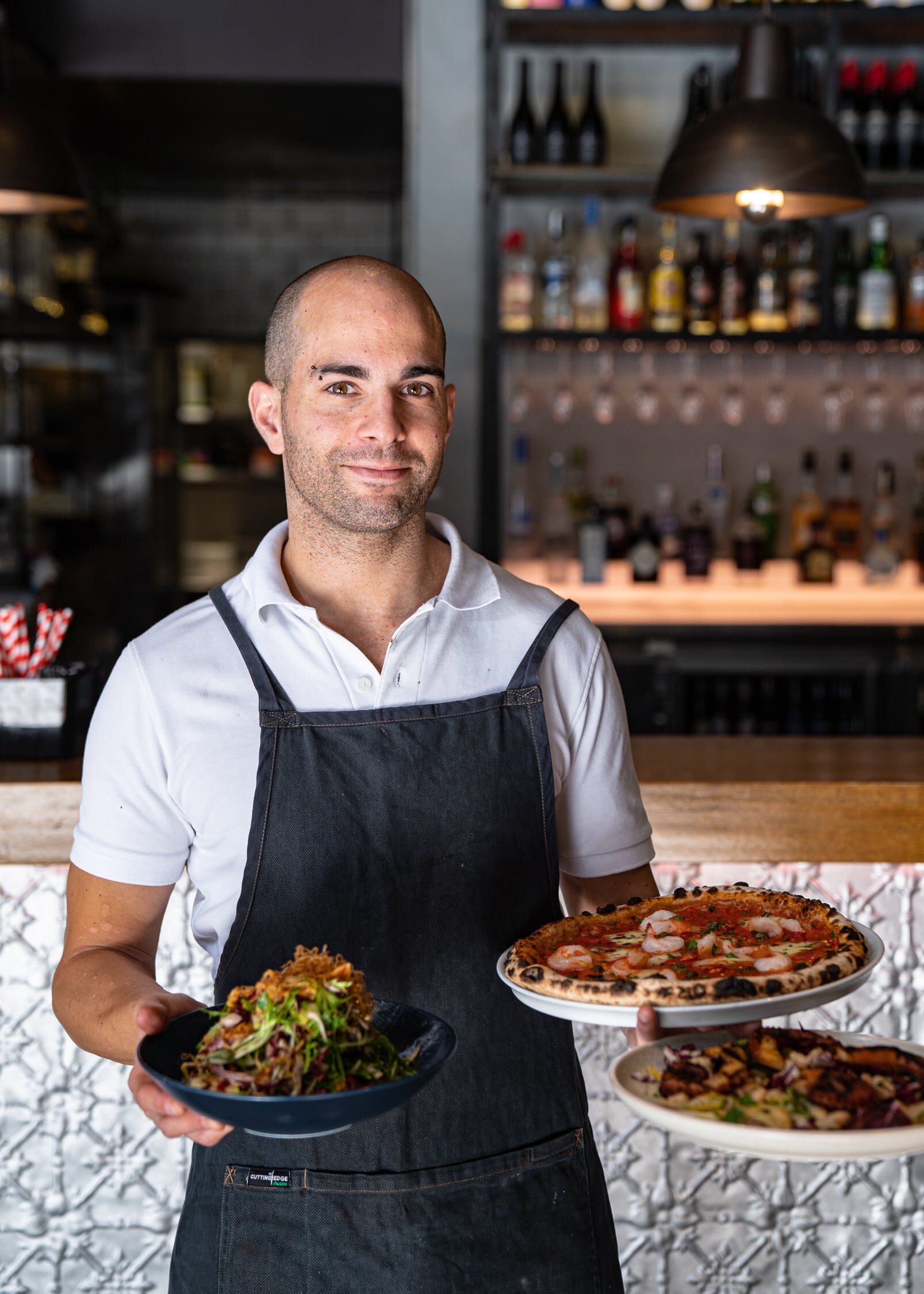 Chef holding pizzas