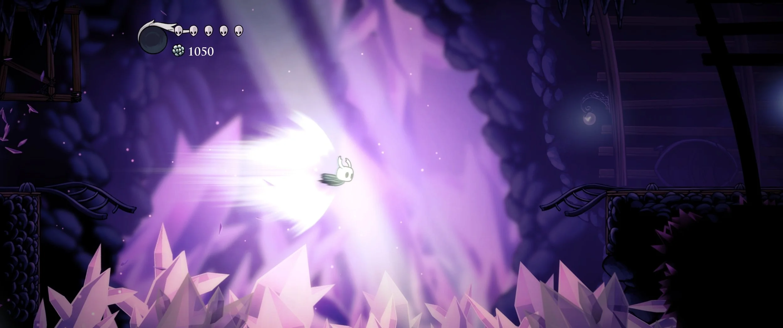 Captura oficial de Hollow Knight com o Cavaleiro em movimento rápido em área com cristais