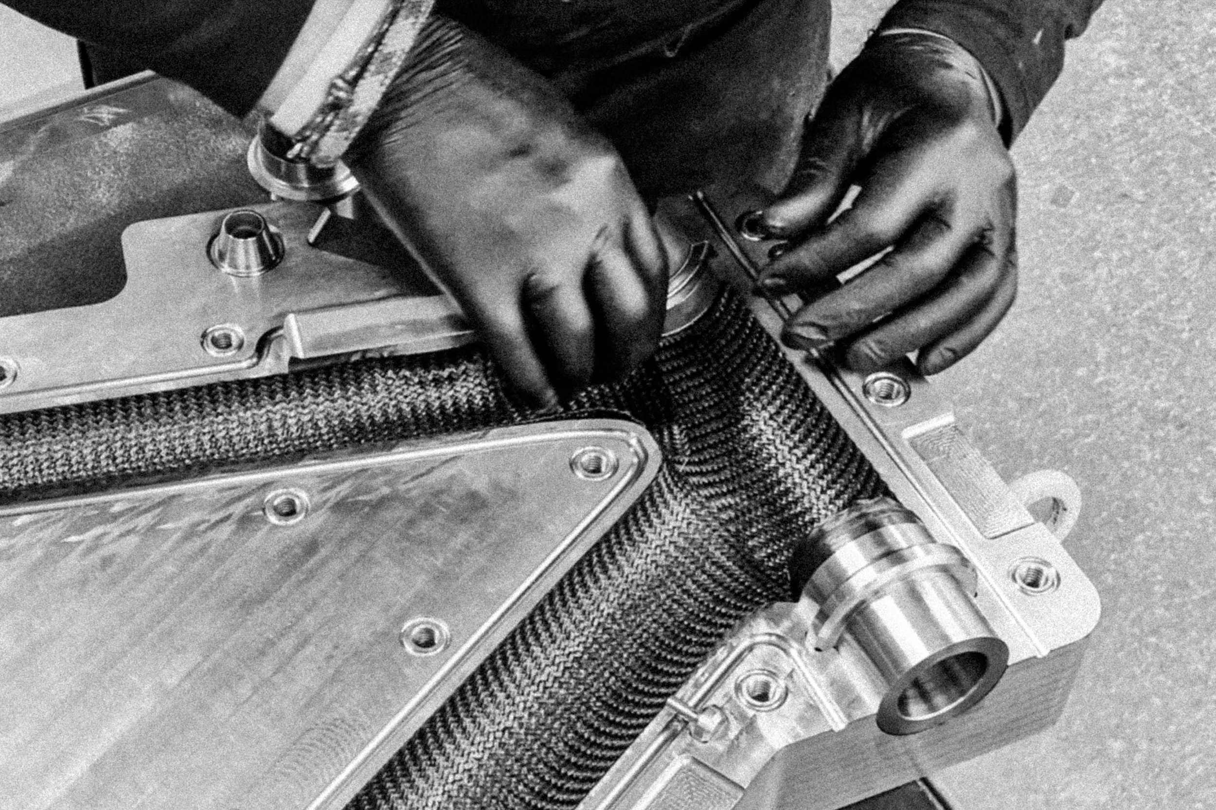 Hands preparing a carbon frame mould during EIDOLON manufacturing process.