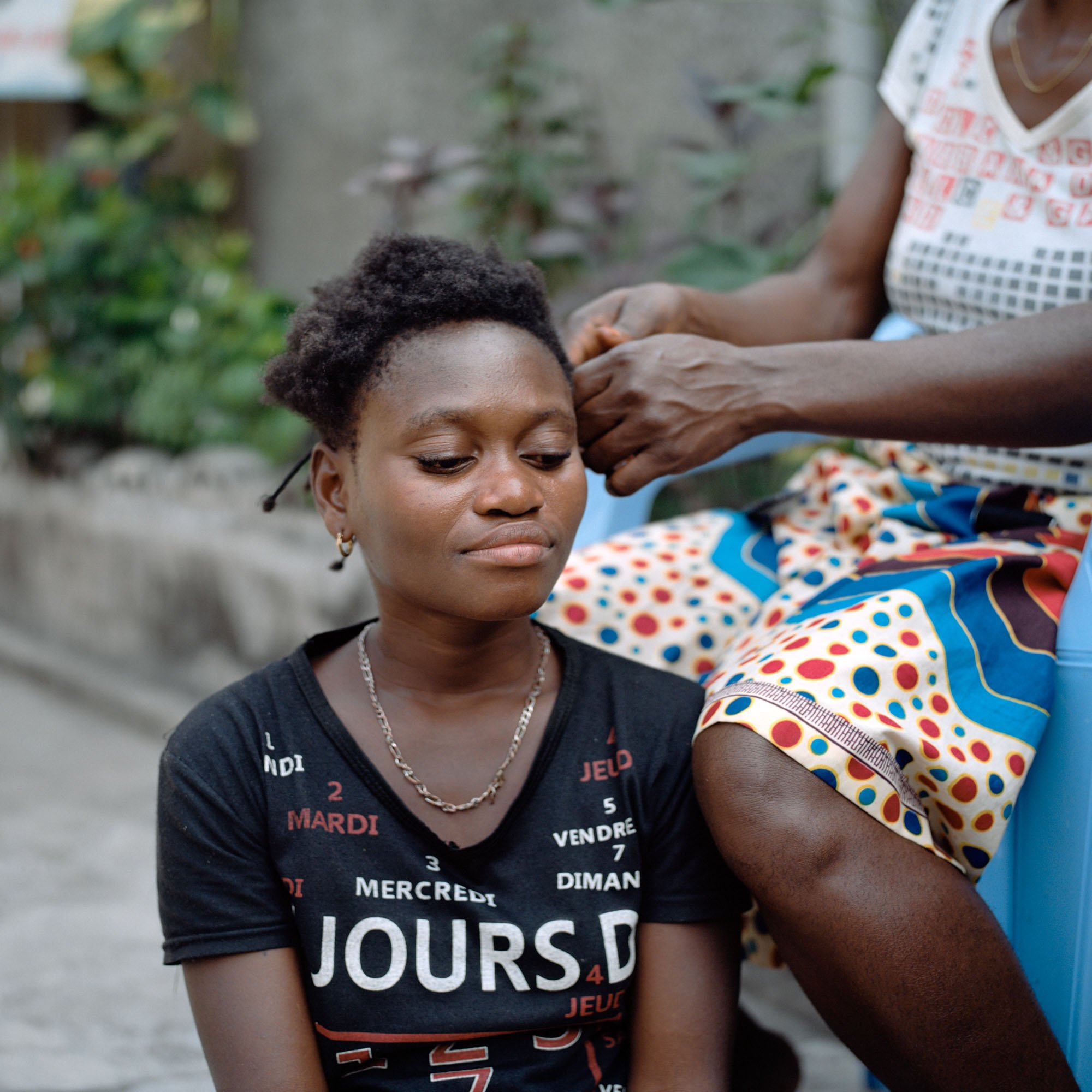 Mambuta braids the hair of Rosette, a young woman from the Bandundu province, east of Kinshasa. At 23, she is about to undergo her second operation. Three years ago, she gave birth to a stillborn child alone. Her husband went to 