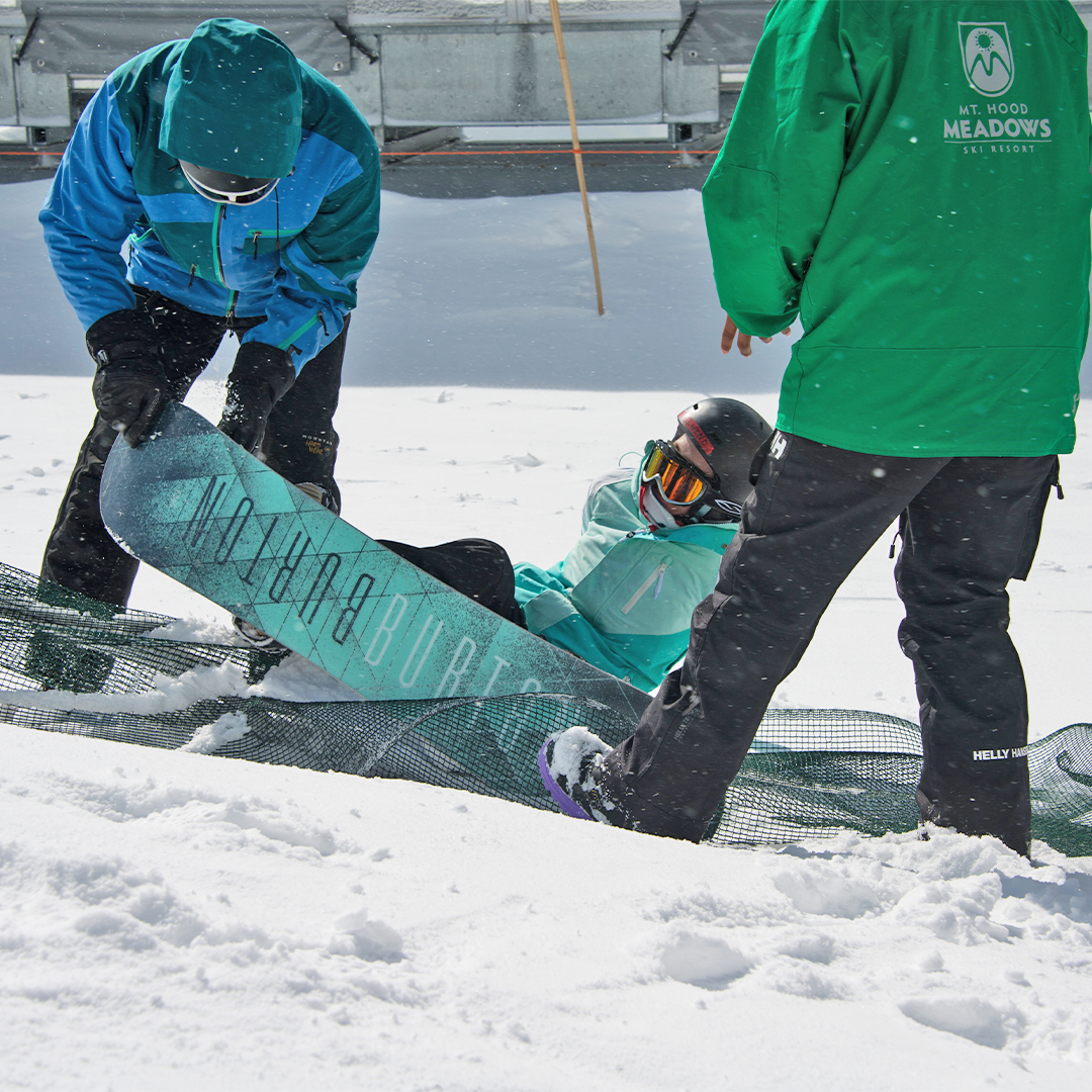 Tailwind being helped up after falling down snowboarding,