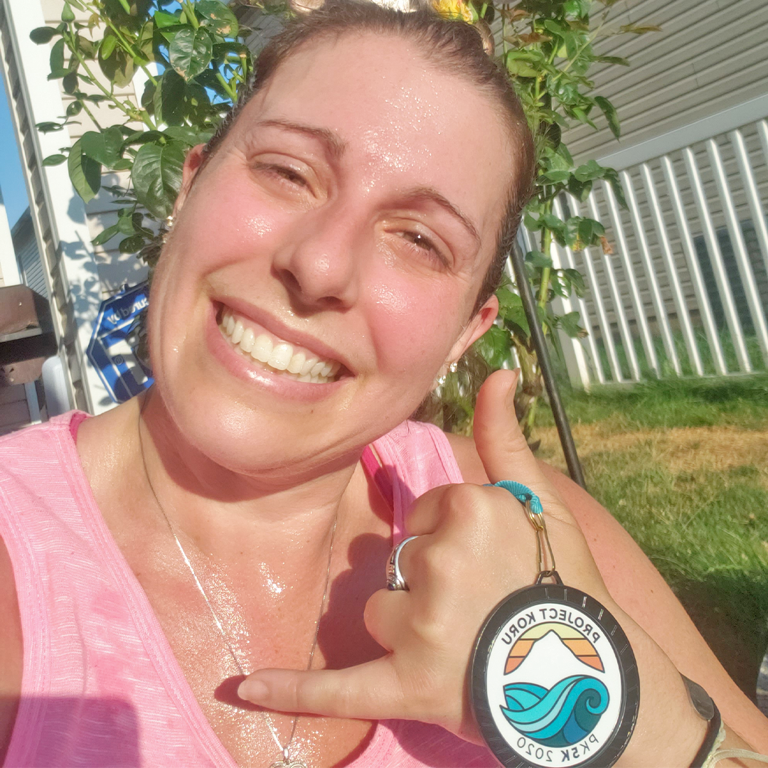 Storm sweating and smiling with her PK5K medal.