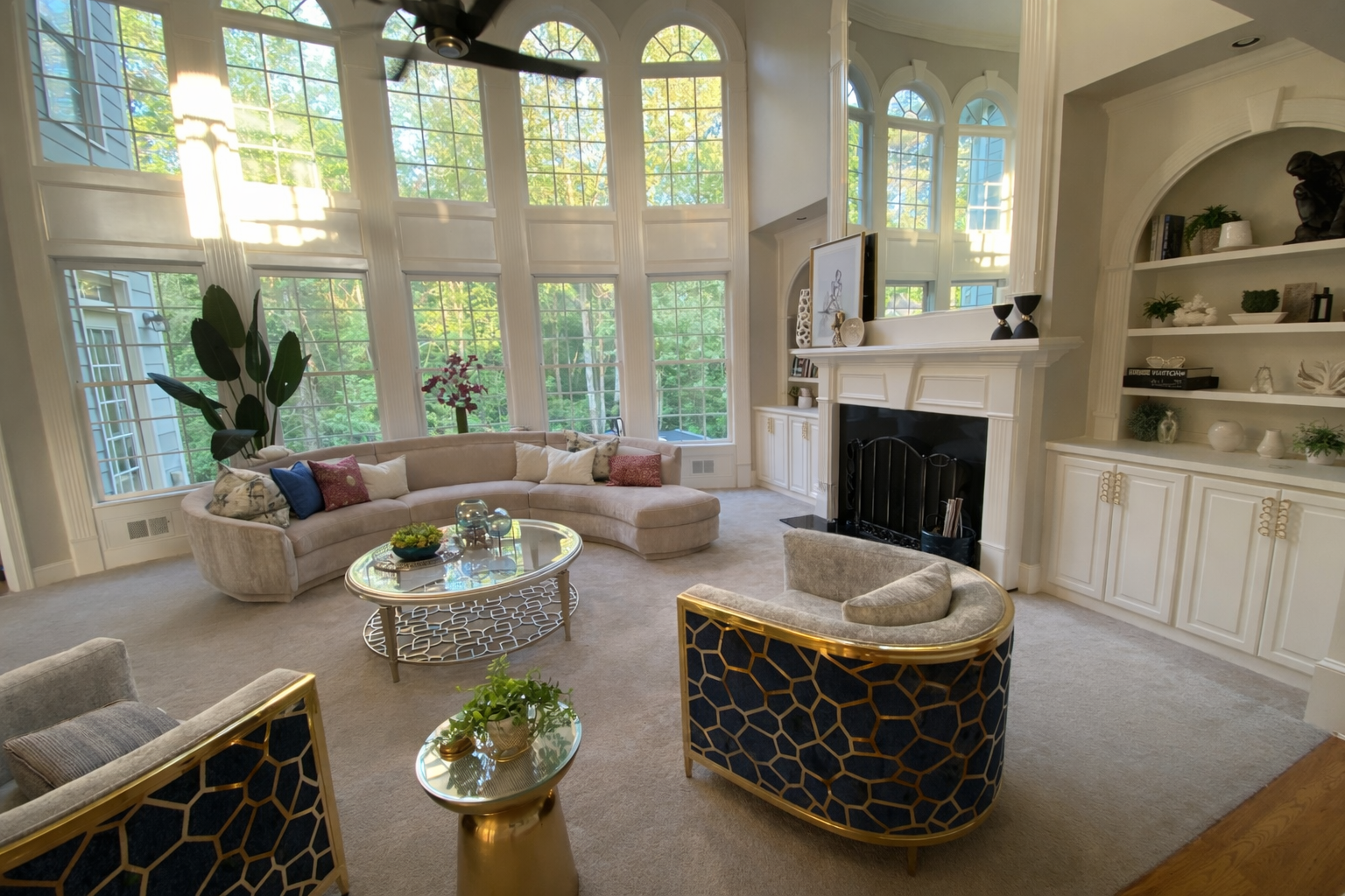 Bright living room with large arched windows, fireplace, and layered seating showcasing interior design direction