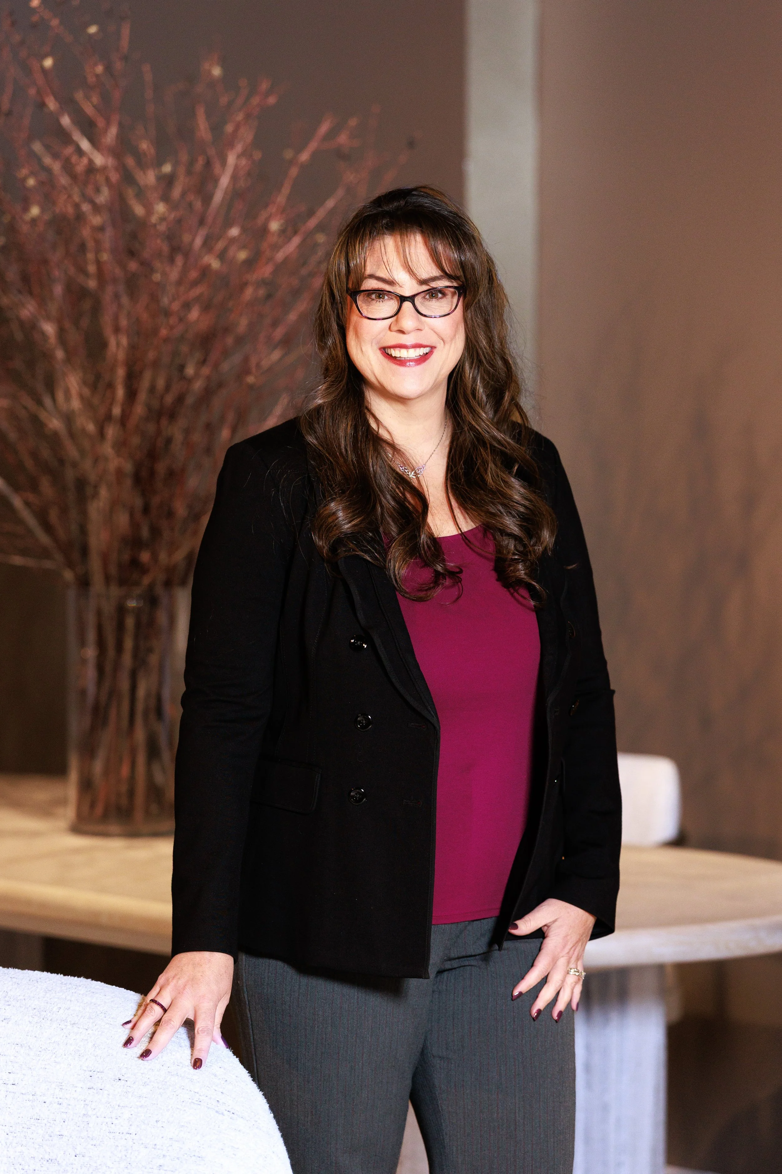 Michele Kiefert, founder and principal designer based in Buford, Georgia, smiling in a professional indoor headshot wearing glasses and a black blazer