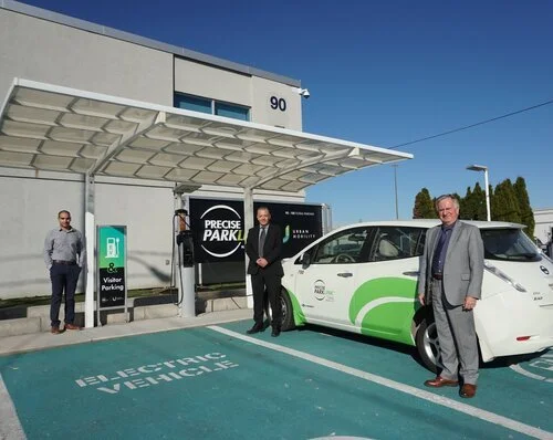 three men standing infront of electric vehicle at Precise ͵͵ office