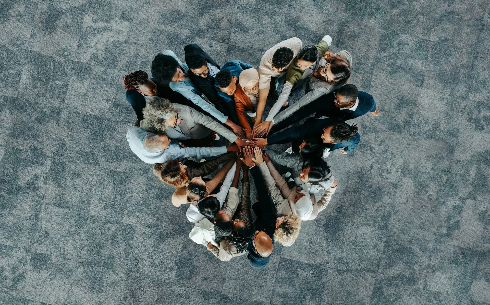 Group of people huddle with hands together in the middle