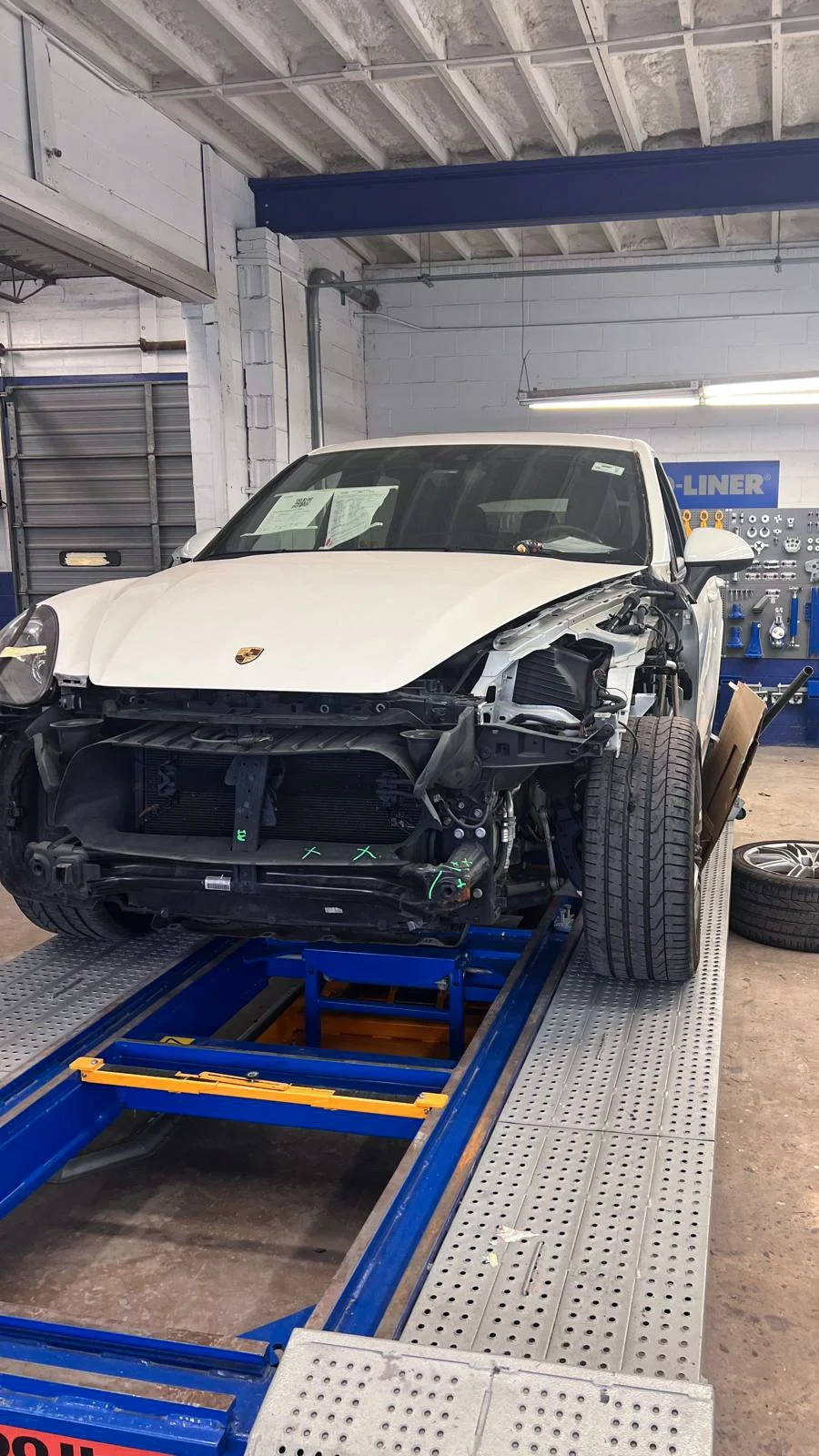 Damaged front end of a Porsche after a frontal collision