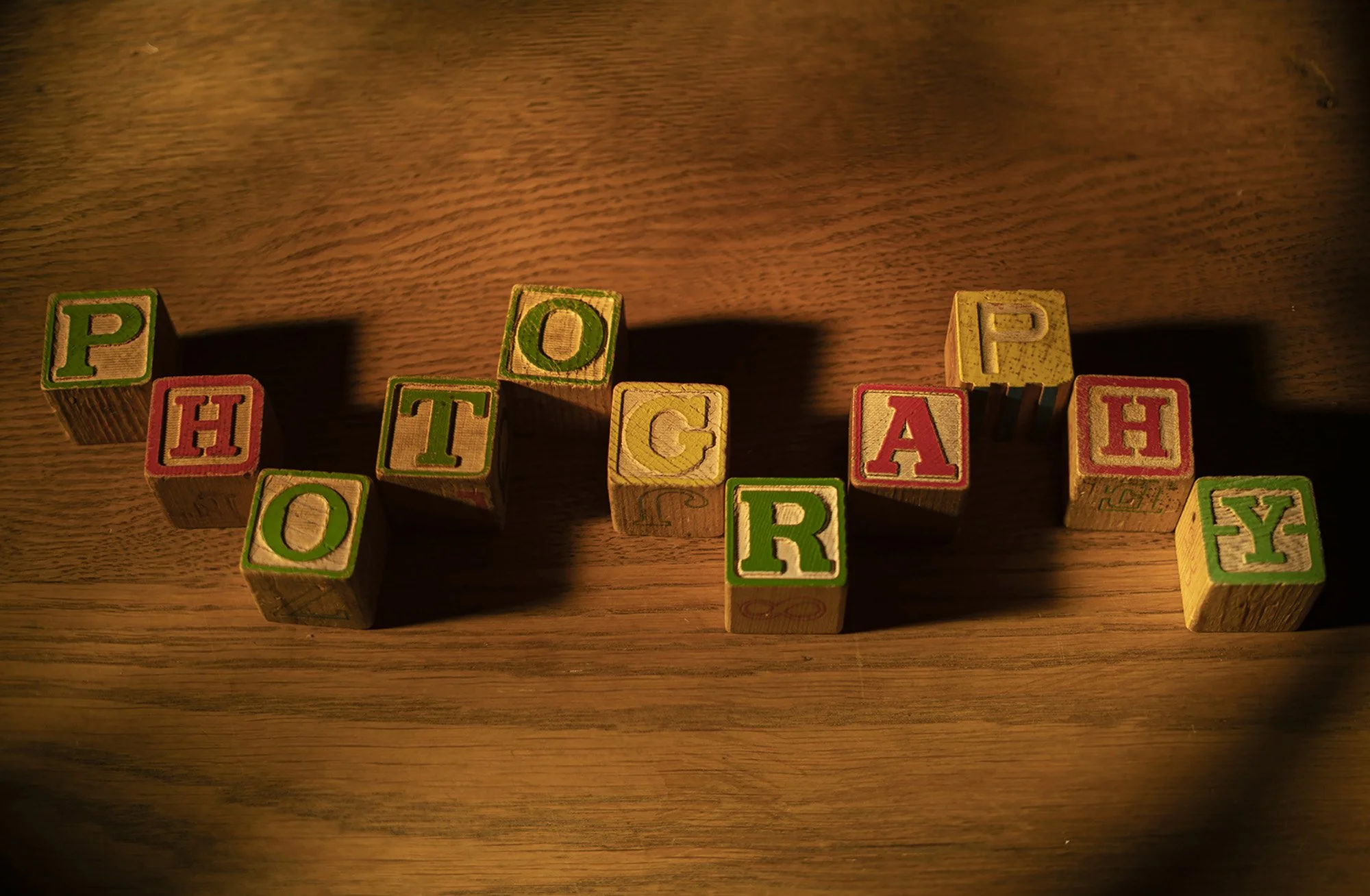 Colorful wooden blocks spelling out the word "POOR" on a wooden surface.