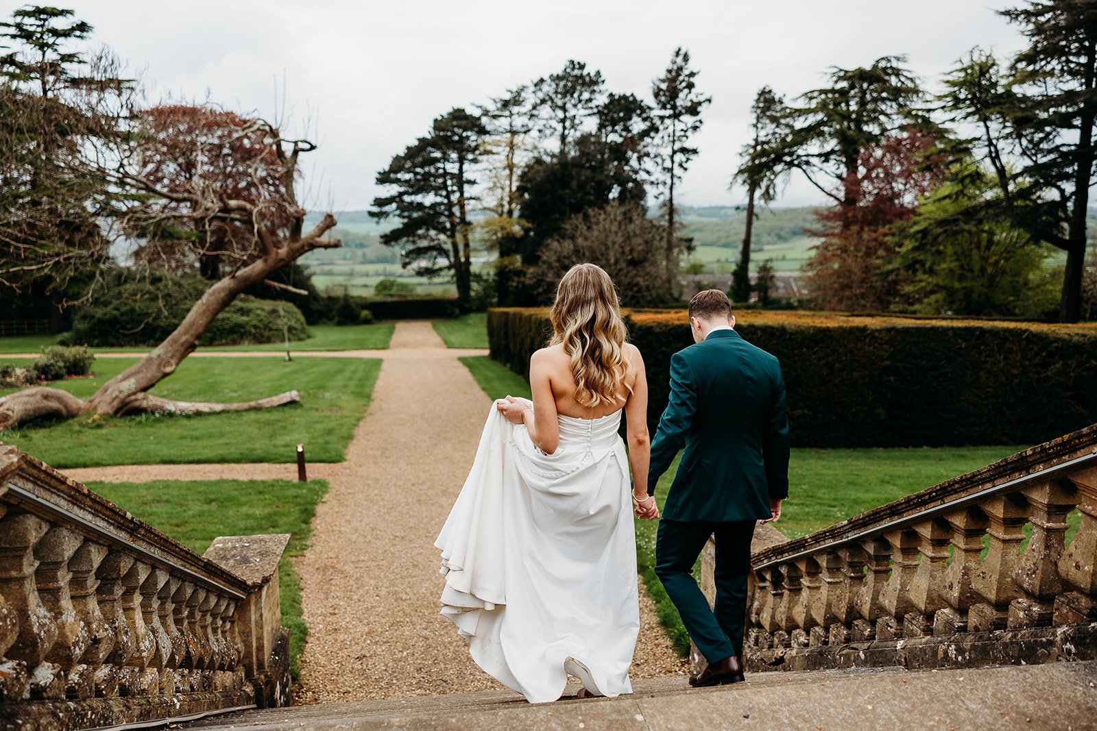 bride and groom walking down Coombe lodge steps