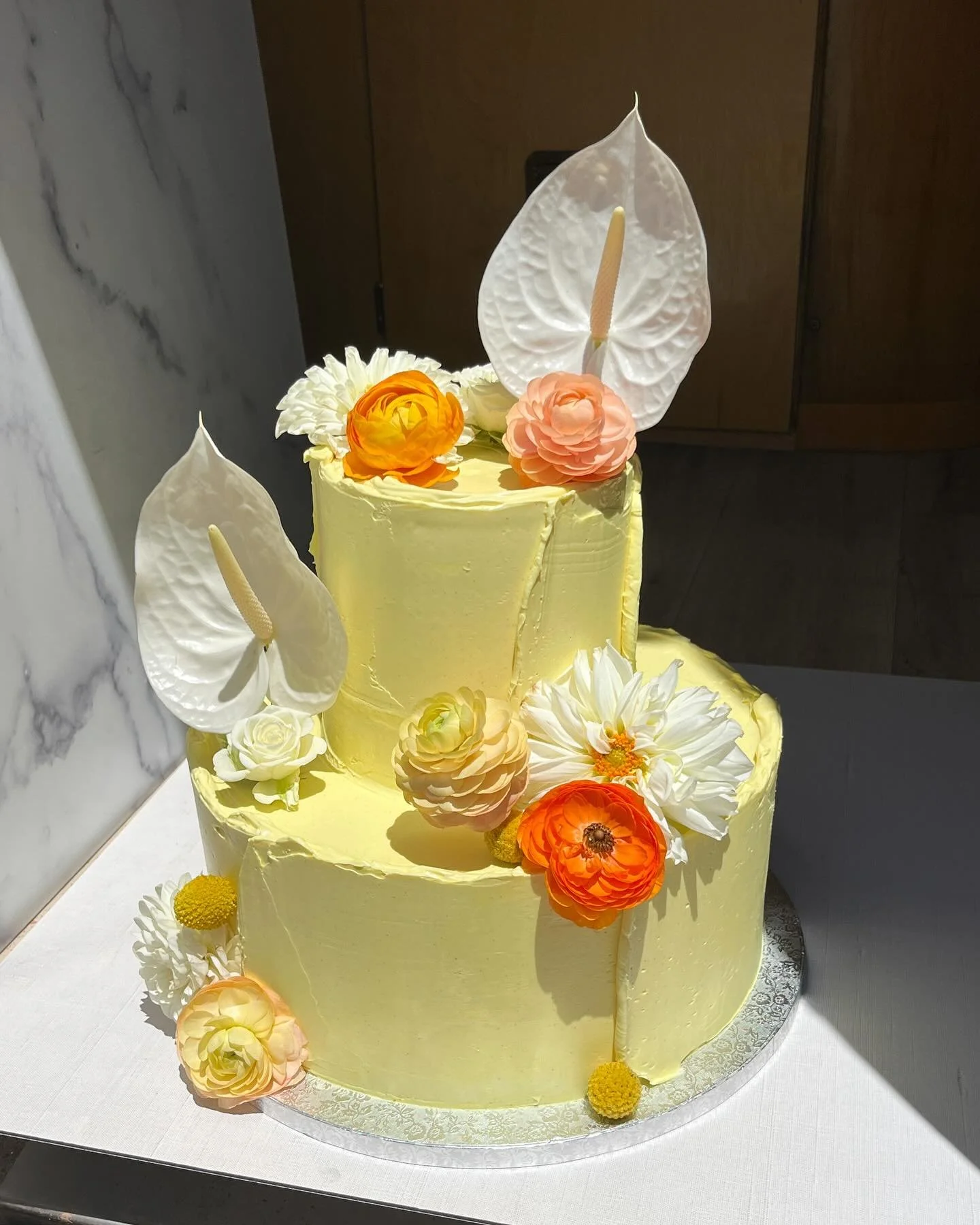 LICKS OF BUTTER YELLOW SWISS🧈🌊yesterday at @sacredsandsjoshuatree 💛💛💛tiered cake is vanilla buttermilk cake filled with passionfruit curd and mascarpone mousse, and turmeric powered vanilla bean Swiss. 1/4 sheet is chocolate hazelnut and black s