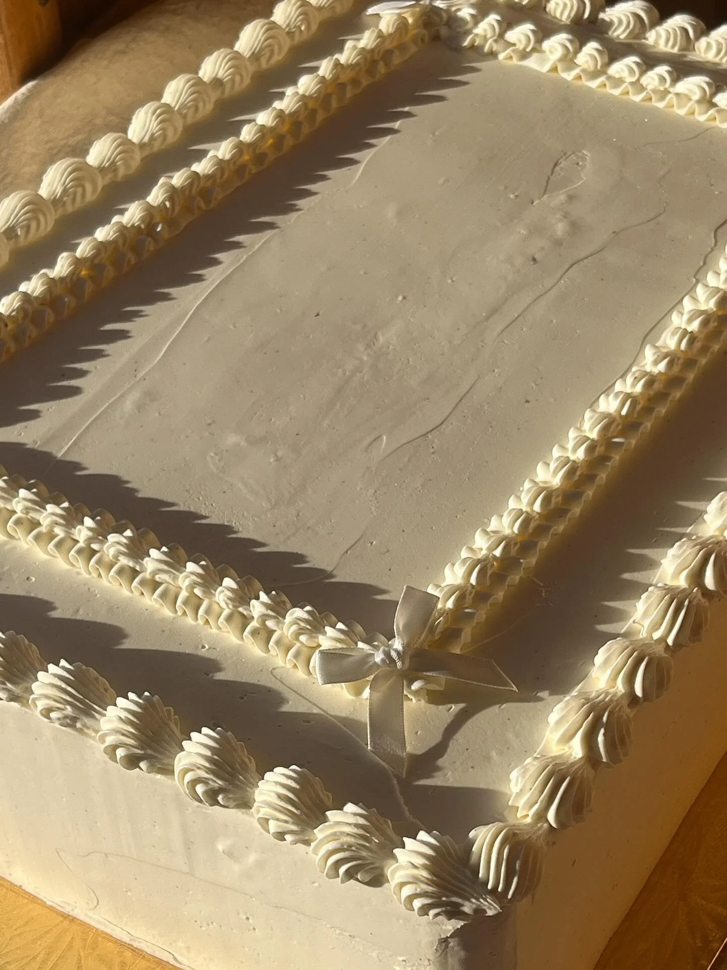 some sweeties from last week🎀🤍Congrats to Kyra &amp; David! Can&rsquo;t really beat all white vintage piping with a few cutie wee bows YA KNOW🤍🎀vanilla sour cream cake, burnt honey chocolate ganache and candied cacao nibs🥛🍫basically chocolate m