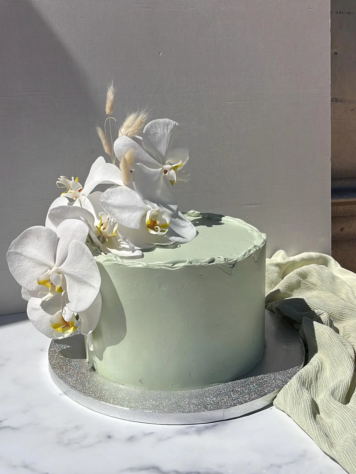 Congrats Austin &amp; Charli🤍🍈orchids doing ALL the heavy lifting💭🤍almond chiffon filled with custard and blackberry lime jam🍋&zwj;🟩

#chiffon #sagegreencake #orchids #PICNICbakedgoods #pioneertown