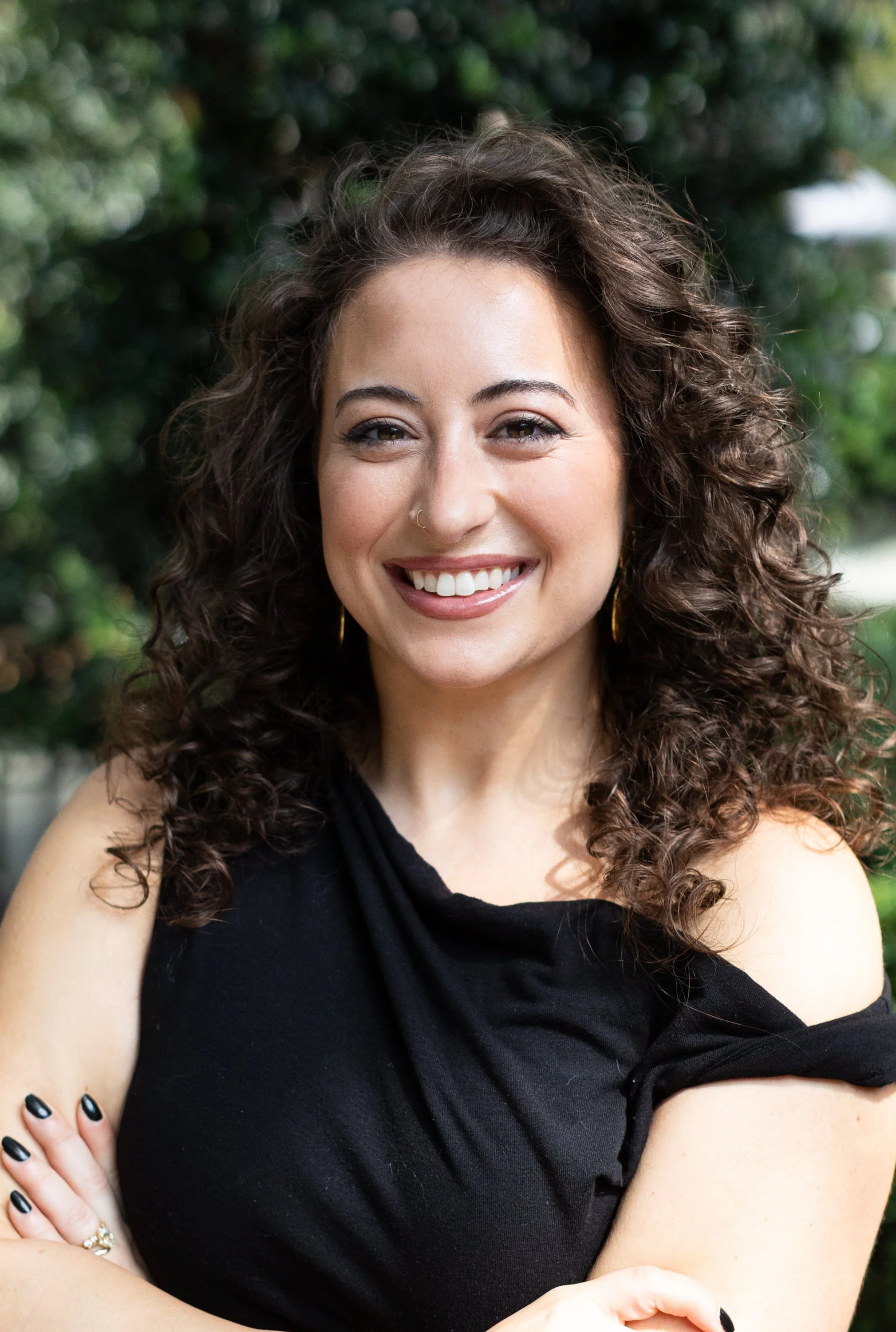 Smiling woman with curly hair and earrings