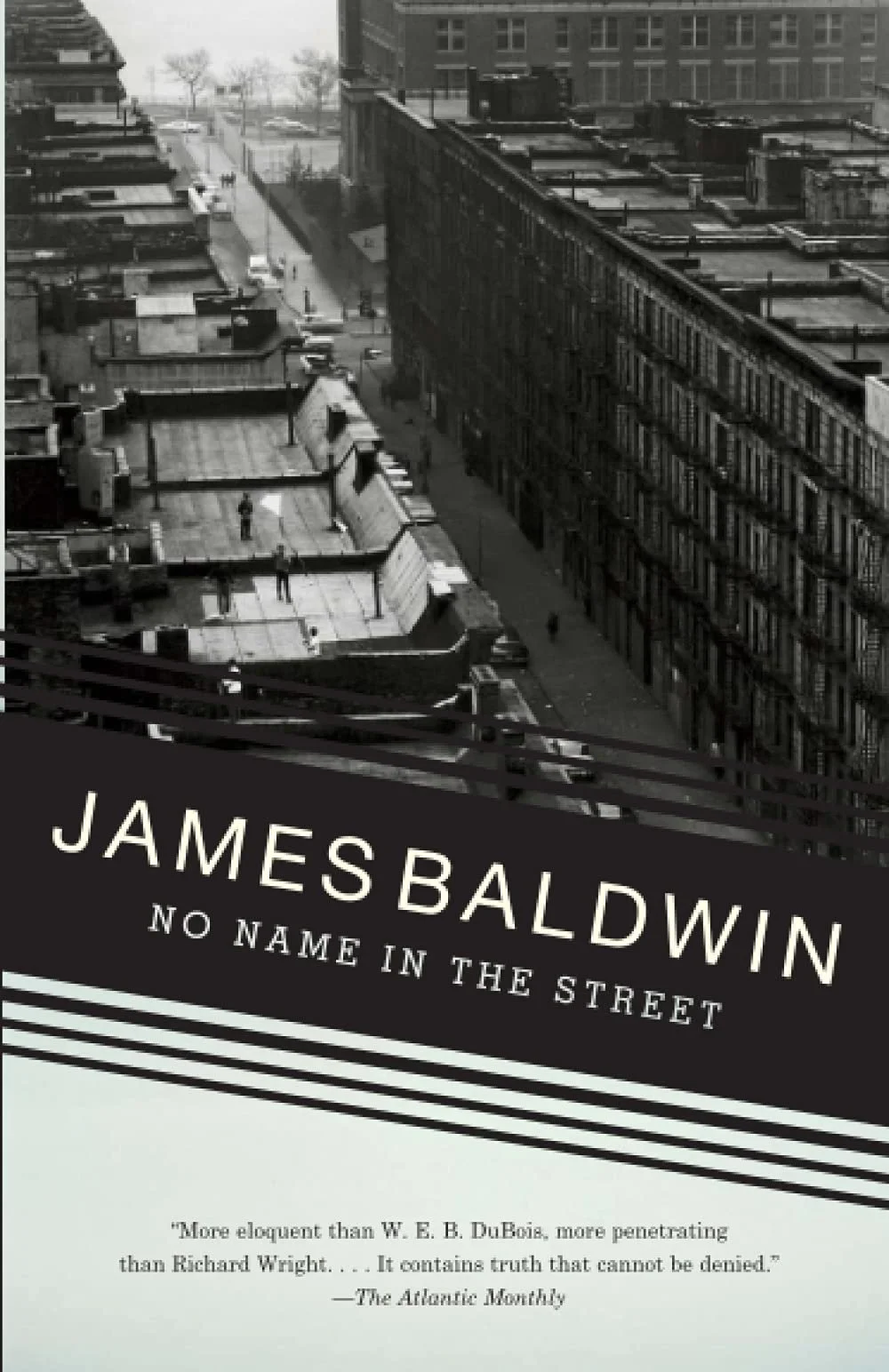 Cover of "No Name in the Street" by James Baldwin, featuring a black-and-white urban landscape with buildings and street view.