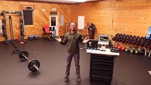 Jacques, owner of the Exercise Design Lab stands in the middle of his facility. Gym equipment and the technology used to collect data about your metabolism, cardiopulmonary, cardiovascular, and neuromuscular systems surrounds him.