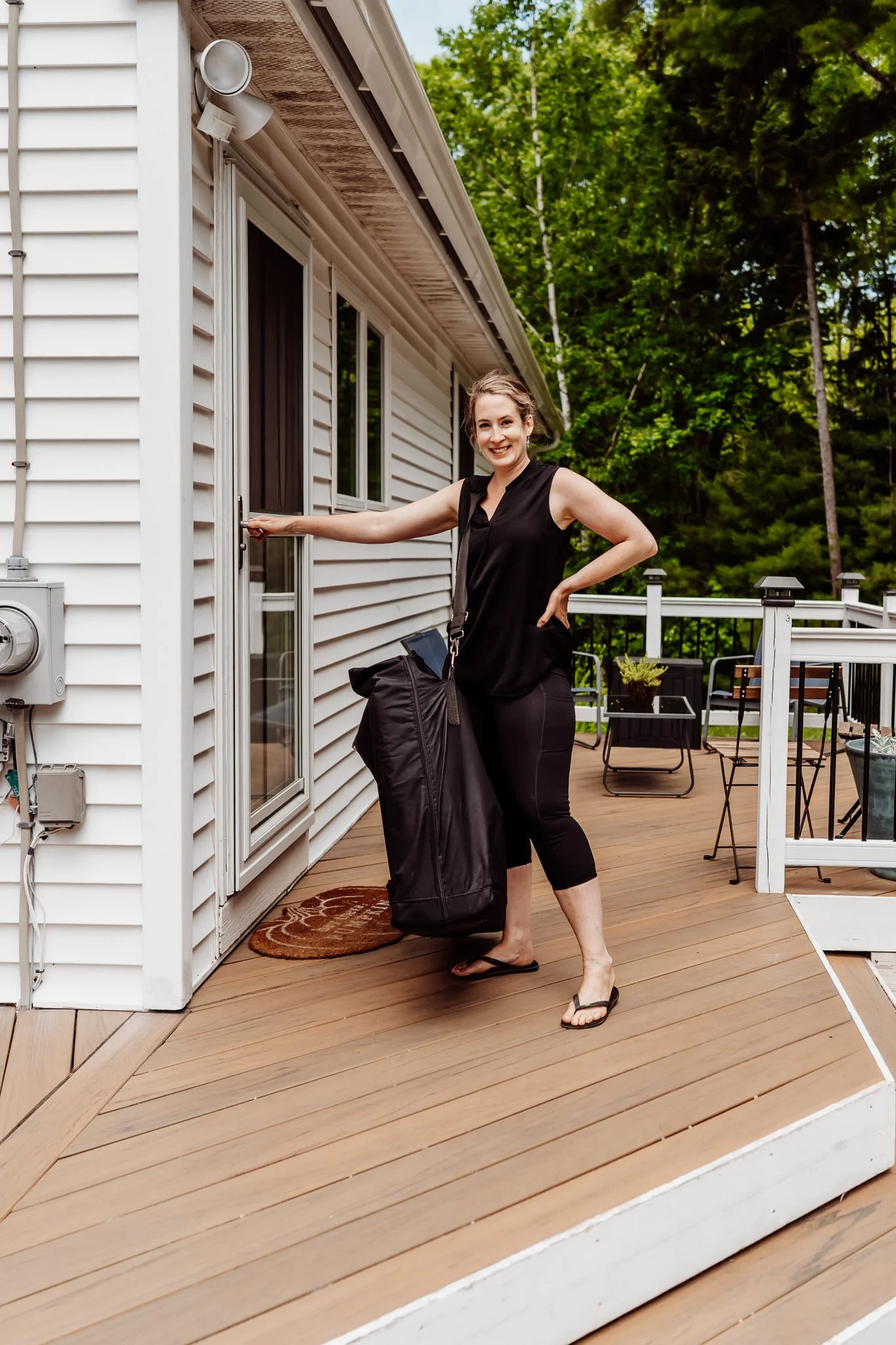 Mobile Massage Therapist carrying a massage table at the front door of a home for on-location travel massage