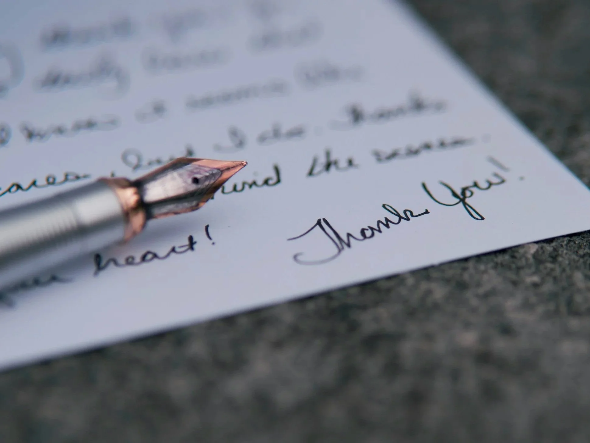 Stylo plume sur une lettre manuscrite, illustrant l'accompagnement personnalisé de l'écrivain public