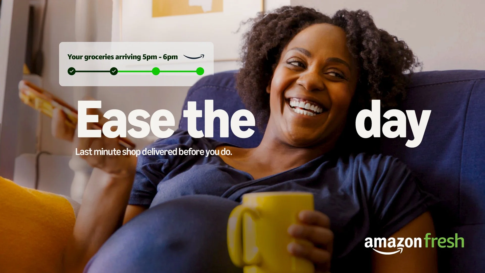 Smiling woman relaxing on a couch holding a yellow mug, with a grocery delivery notification overlay from Amazon Fresh indicating delivery between 5 pm and 6 pm.