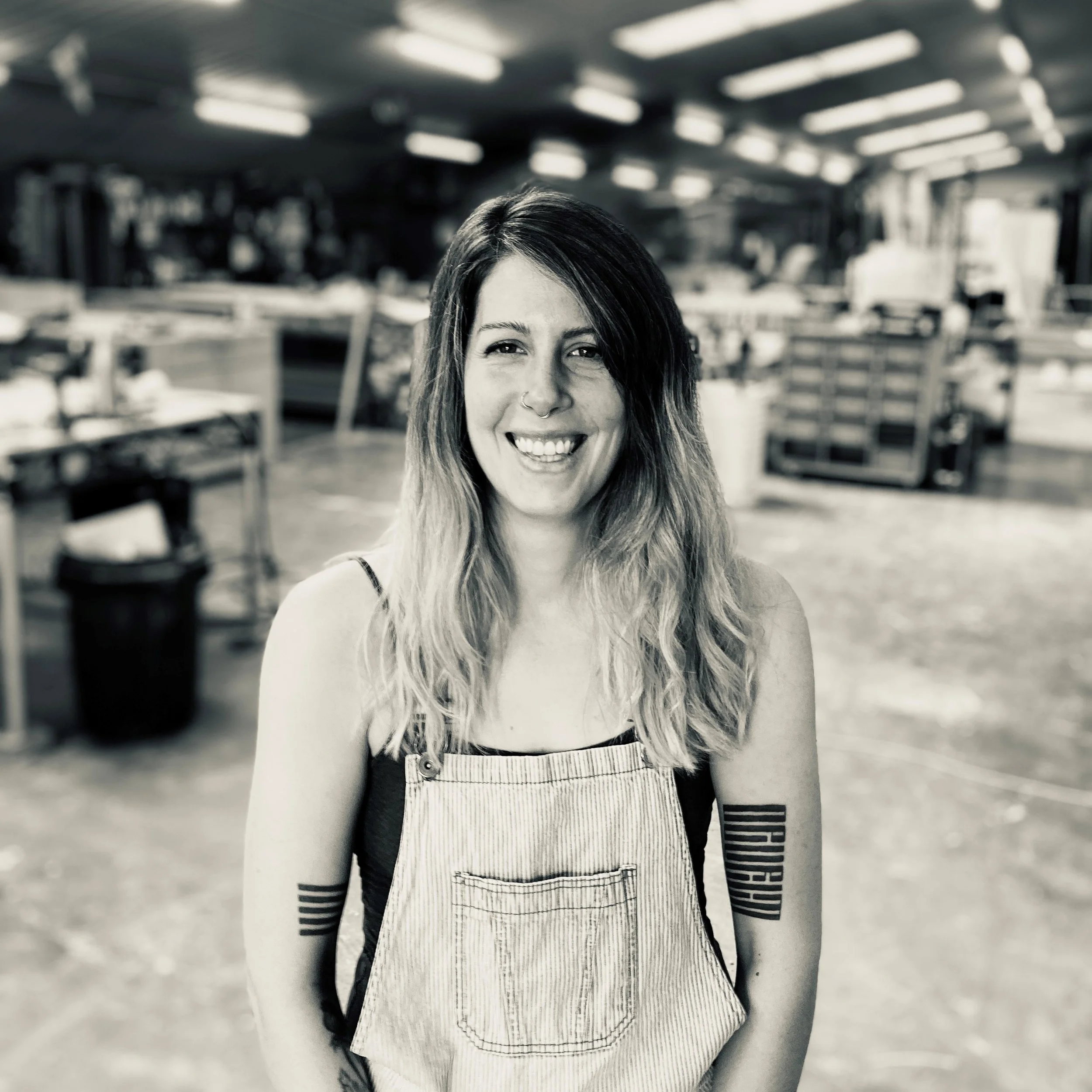 Creator International Project Manager smiling in a scenic carpentry workshop designing and fabricating set pieces