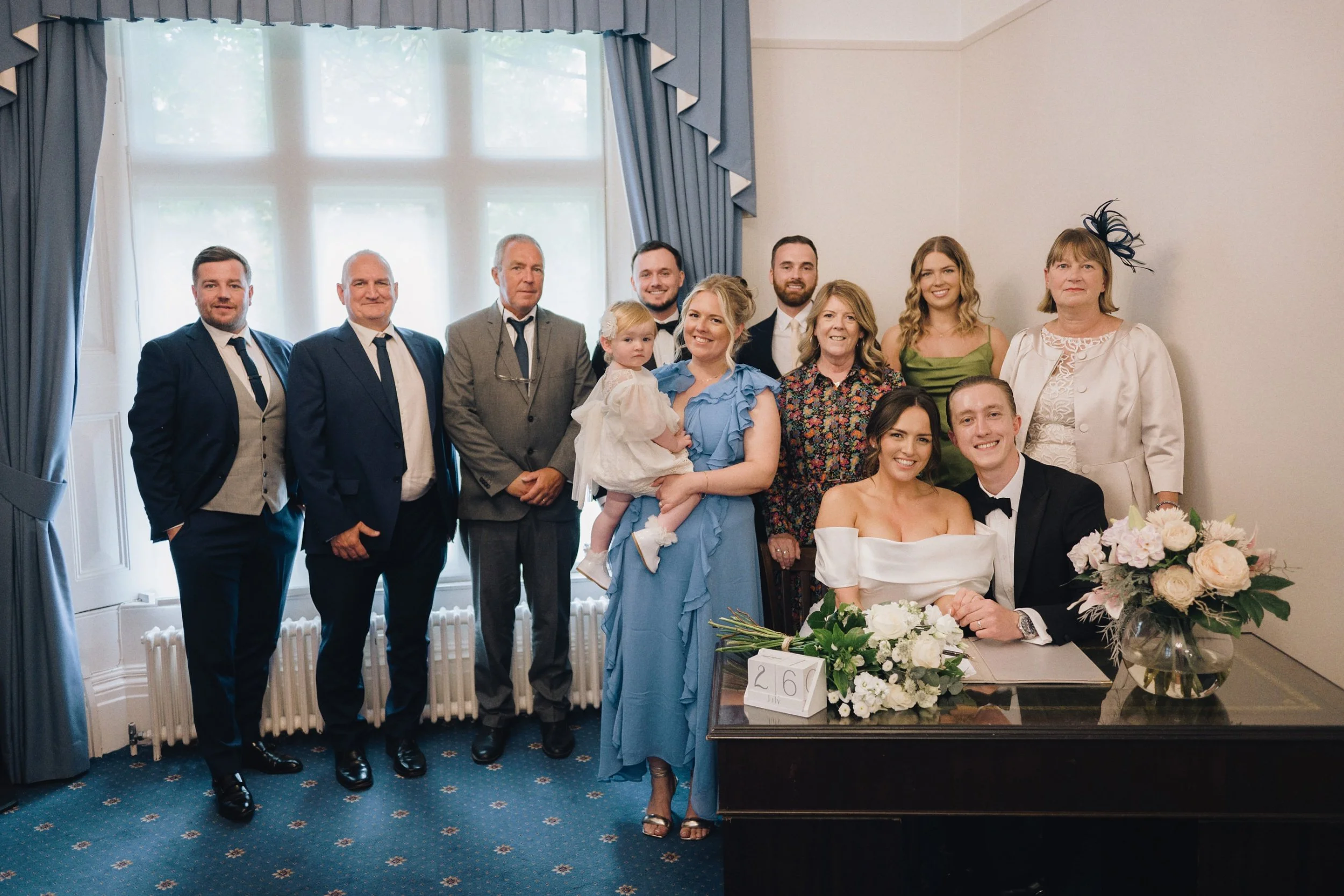 The guests gather round for the wedding photographer as they stand for a group photo