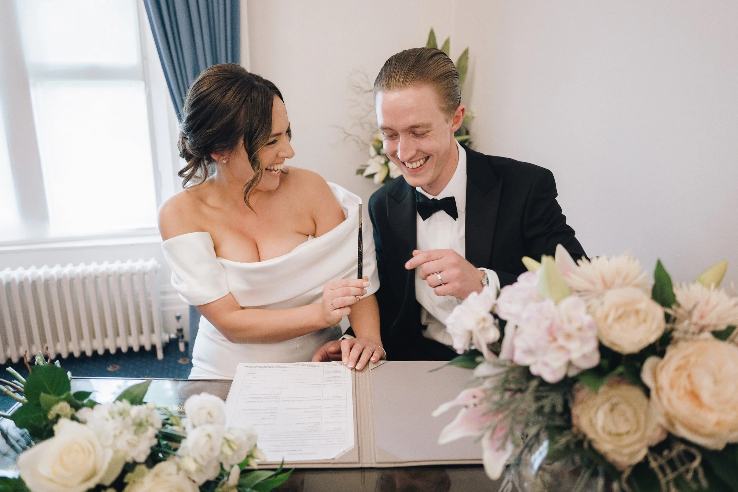 Bride and groom sign their marriage papers at Guildford Register Office