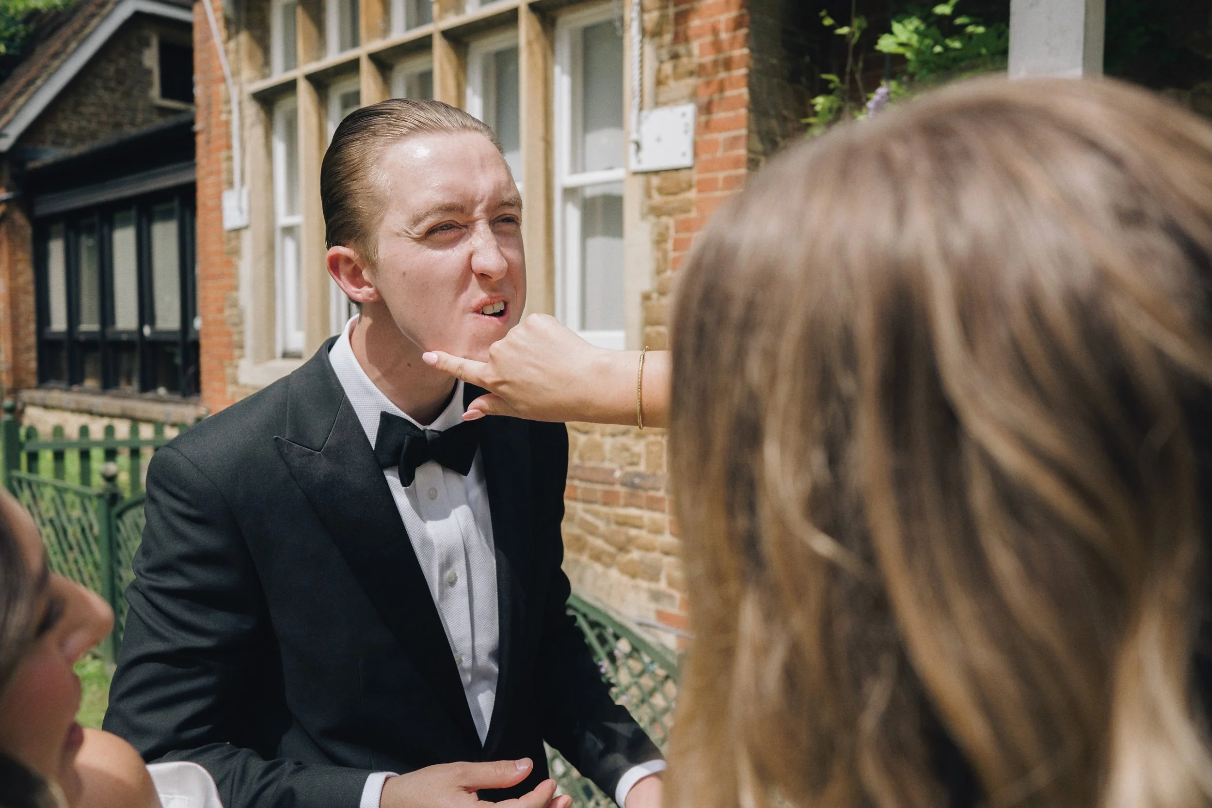 Wedding guests mingle with the groom after the wedding ceremony in Guildford